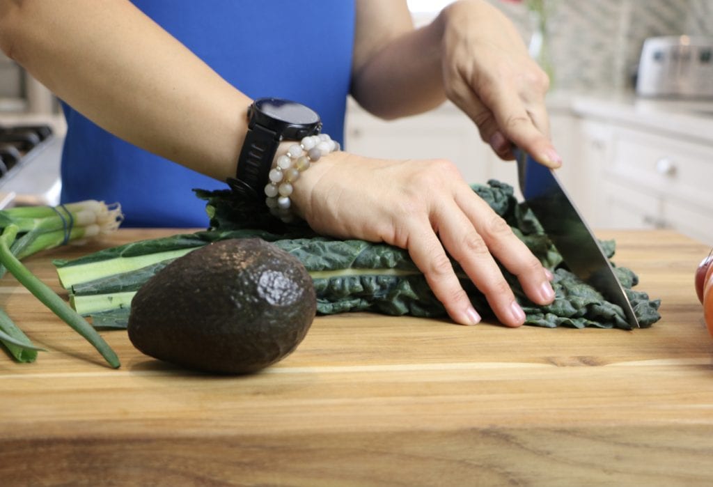 Lacinato Kale on a cutting board being cut