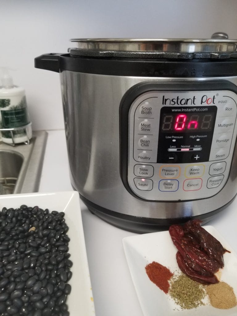 Instant Pot with black beans and spices to make homemade beans