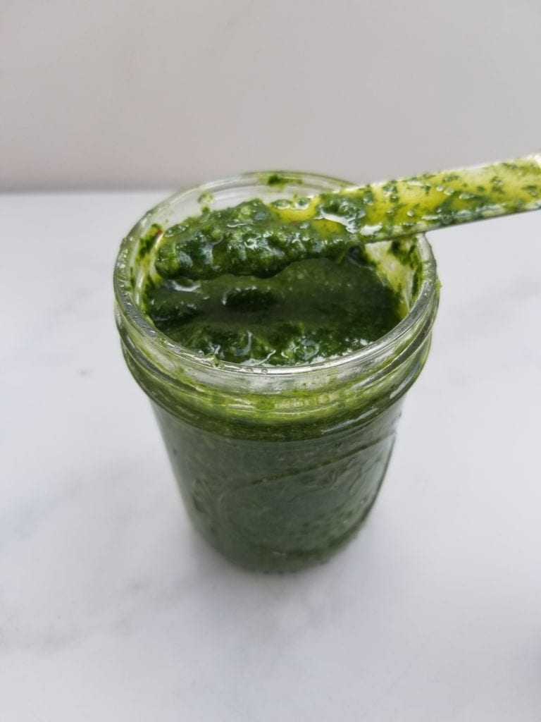 jar of chimichurri with a knife slathered with a little