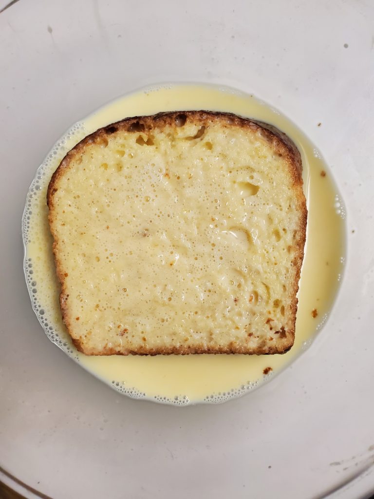 Slice of brioche bread soaking in egg