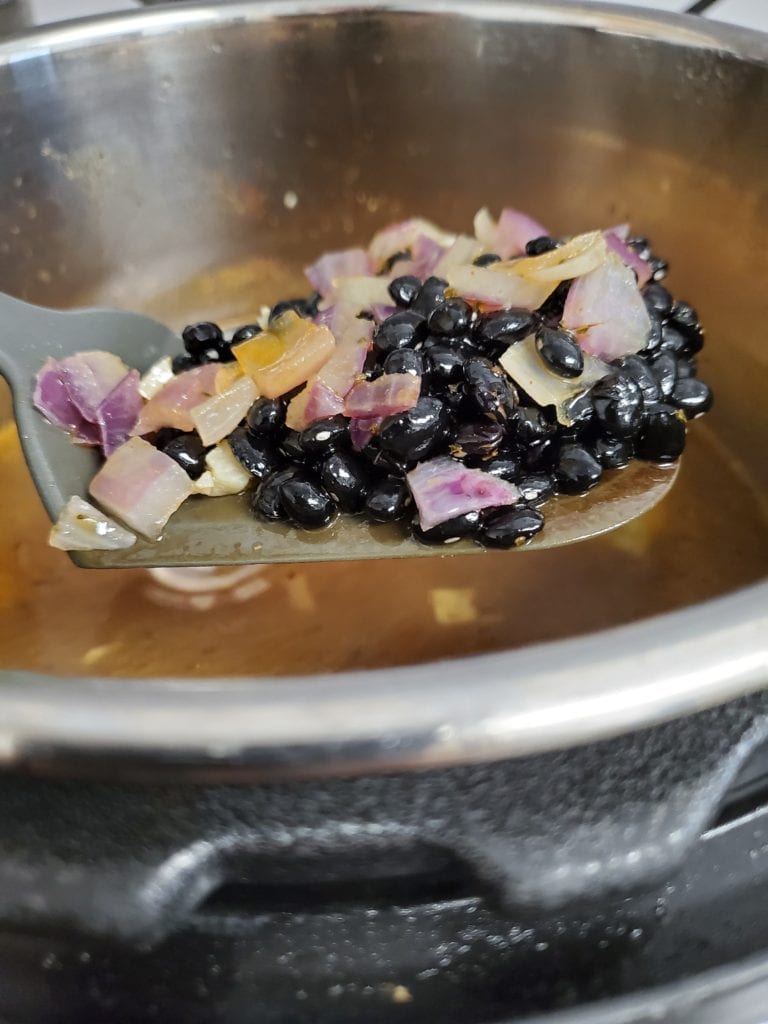 spoonful of black beans, onion, and garlic right out of the pressure cooker