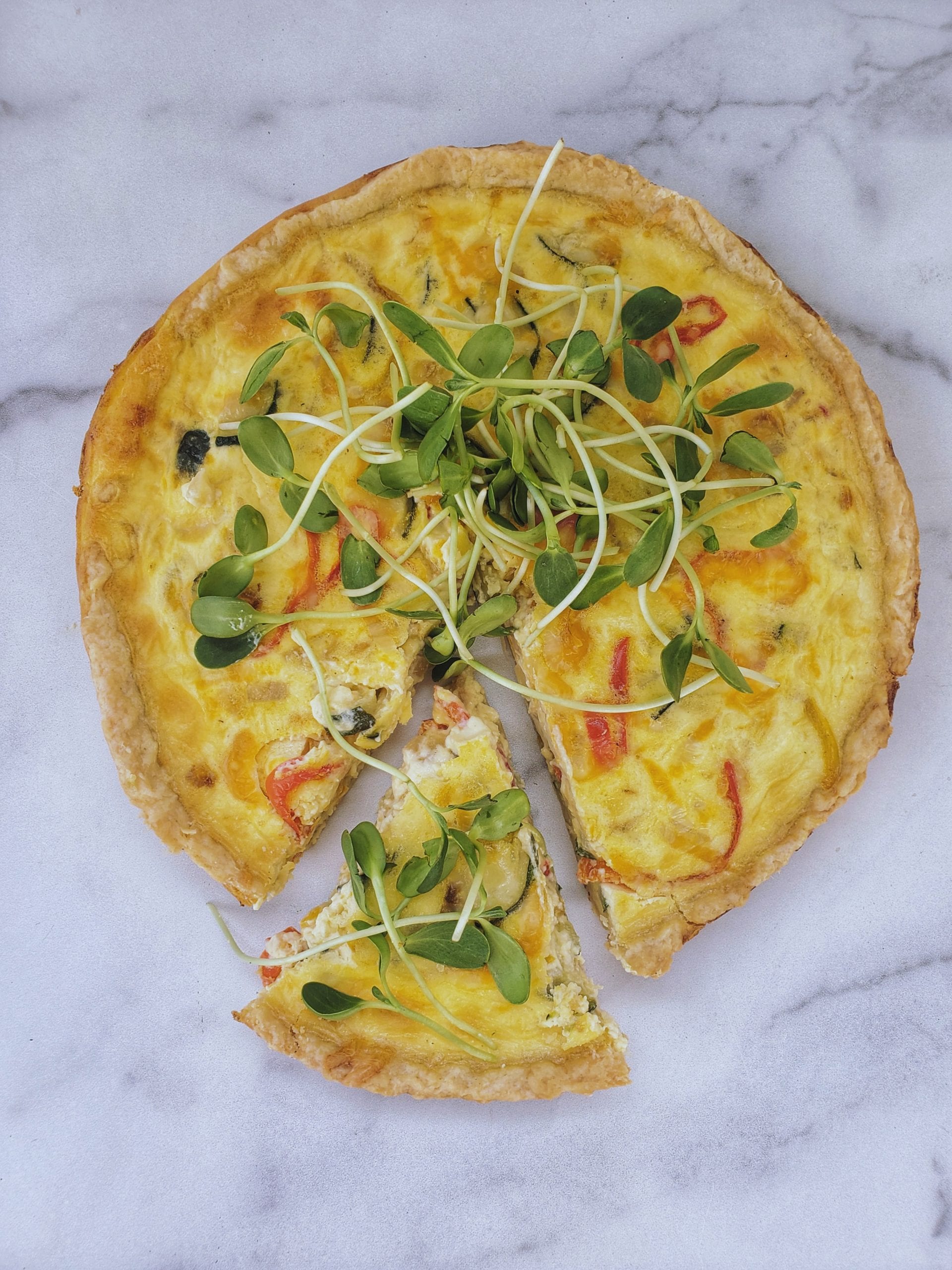 a whole quiche with one slice cut