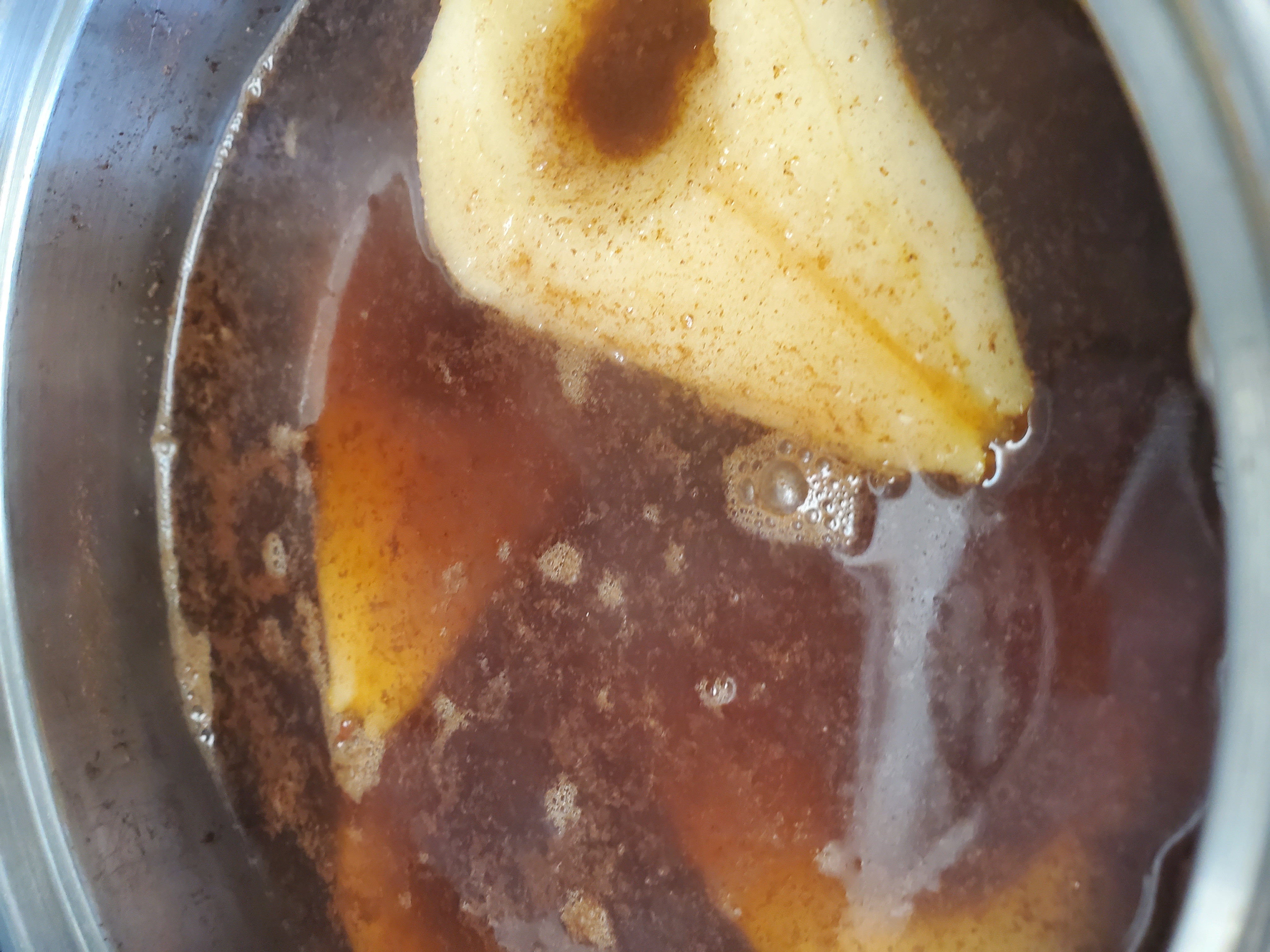 pears cut in half submerged in cinnamon water