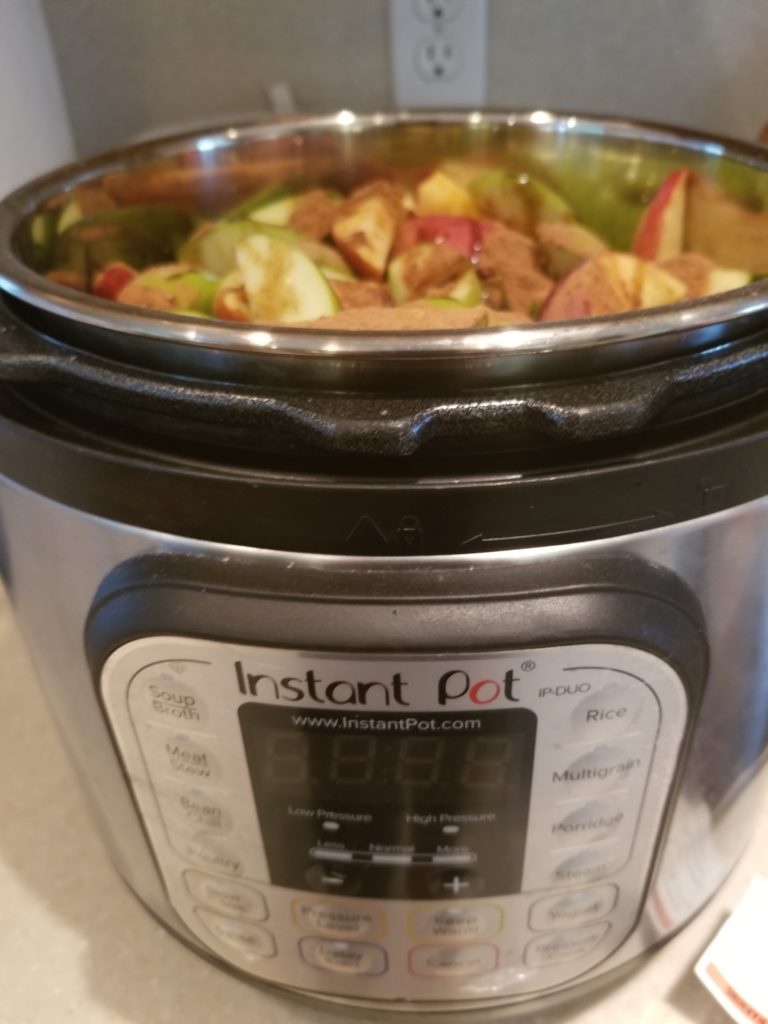 Instant Pot filled with cut apples and cinnamon
