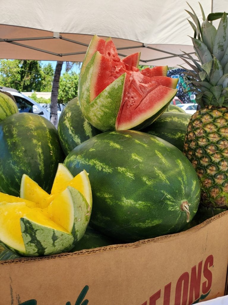 yellow and red watermelon at a road stand