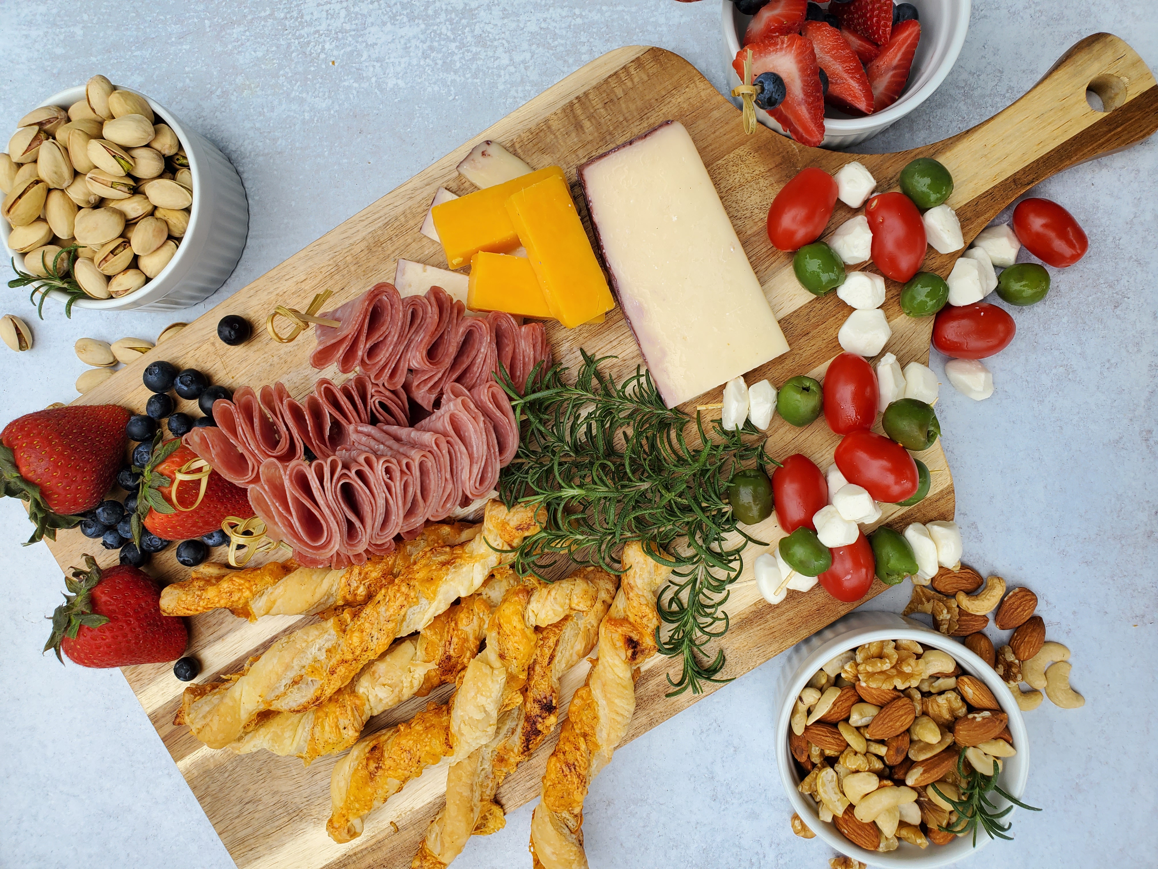 Cheeseboard with salami, mix of cheeses, and nuts