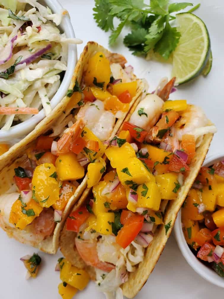 Shrimp tacos with slaw and mango salsa on a plate