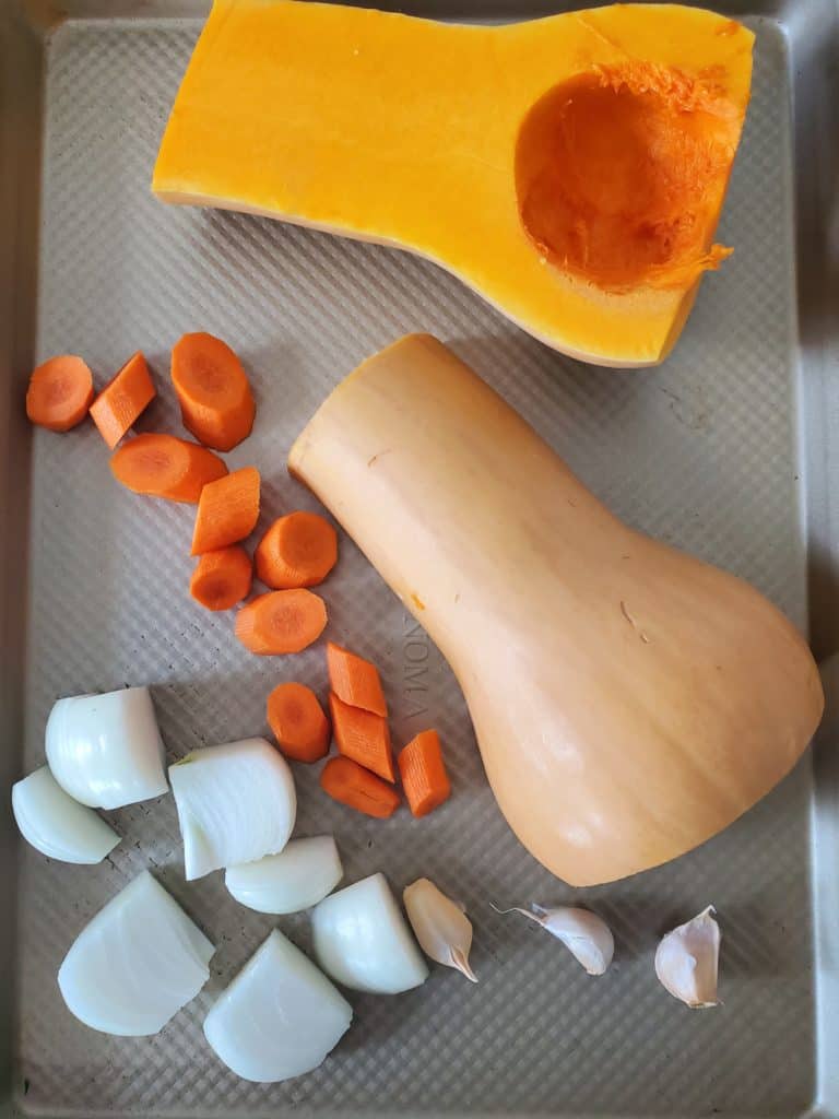 ingredients for butternut squash soup on a sheet pan - butternut squash, onion, garlic, carrot