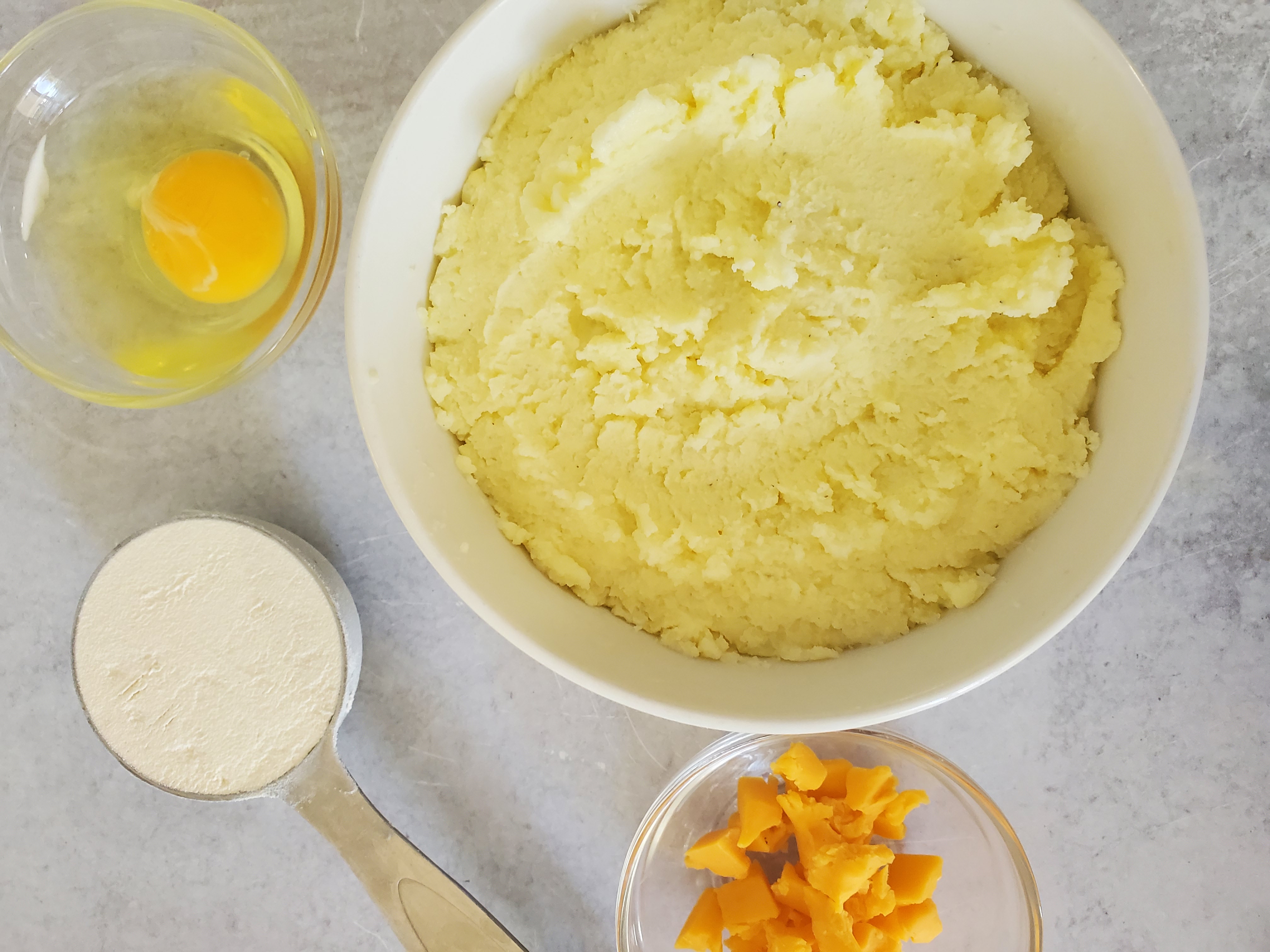 Ingredients for mashed potato waffles:  mashed potato, cheddar cheese, flour, and an egg