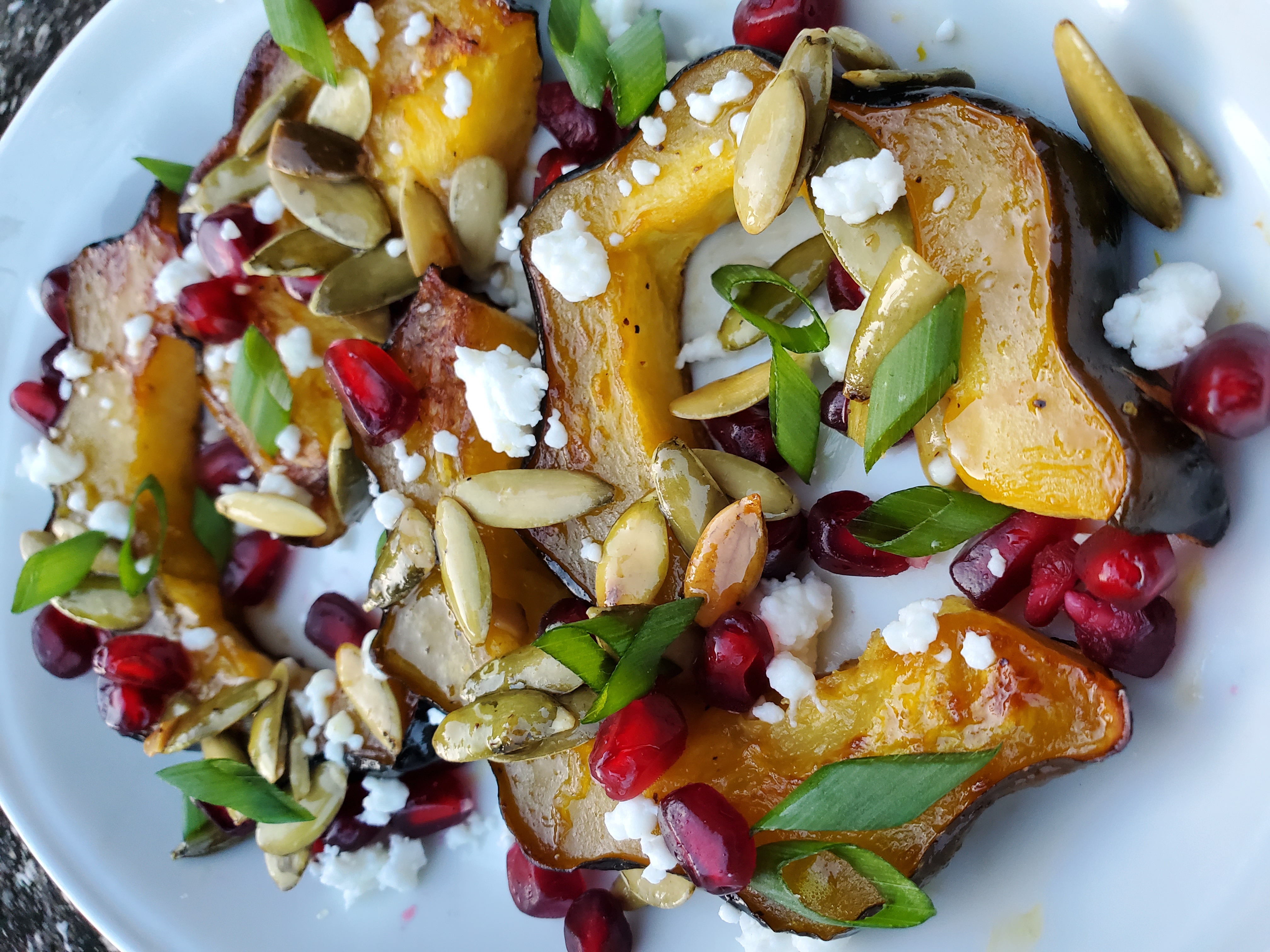 Roasted Acorn Squash with Pomegranate Arils, Feta Cheese, and Pumpkin Seeds