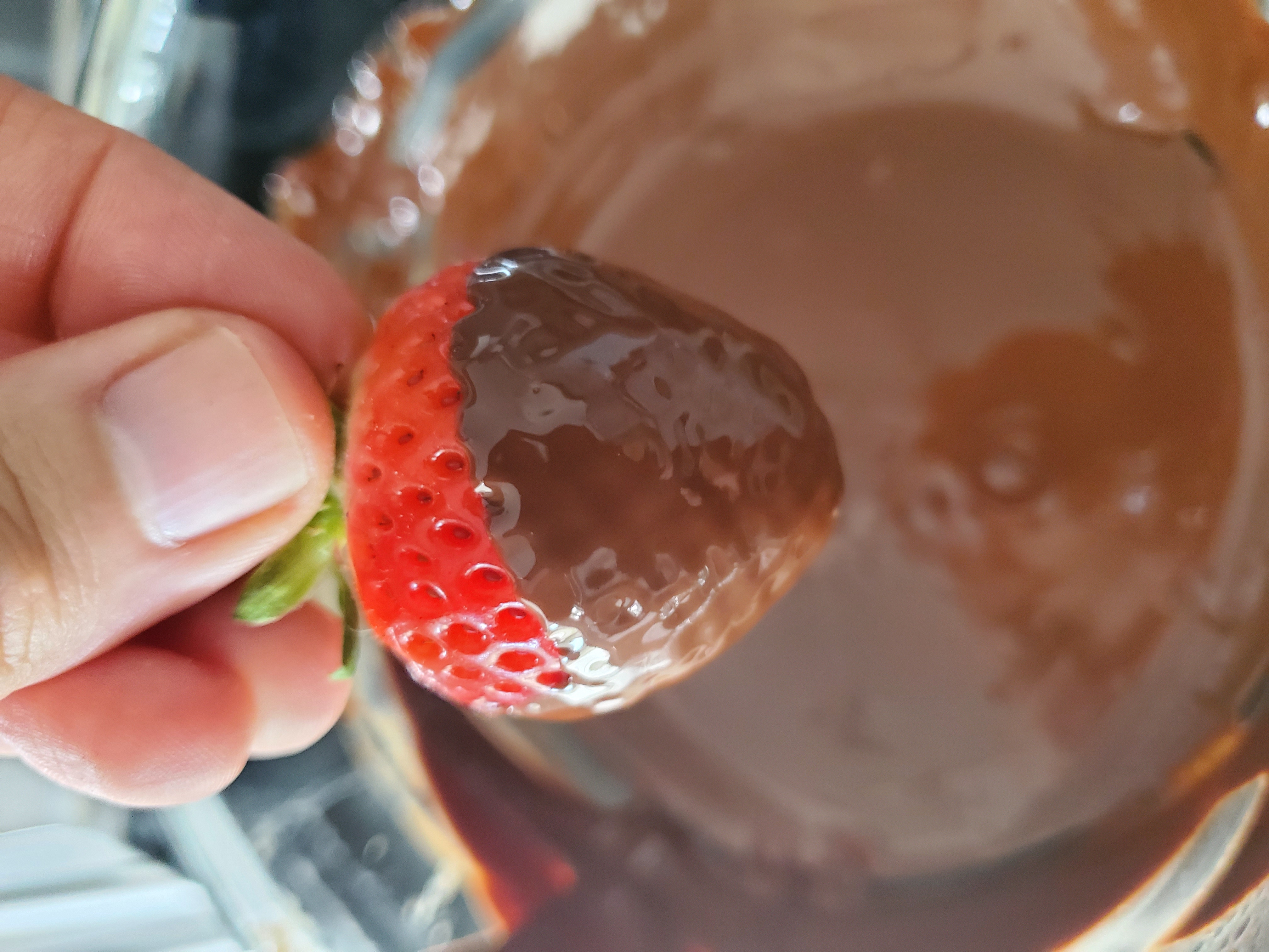 One strawberry dipped in the melted chocolate