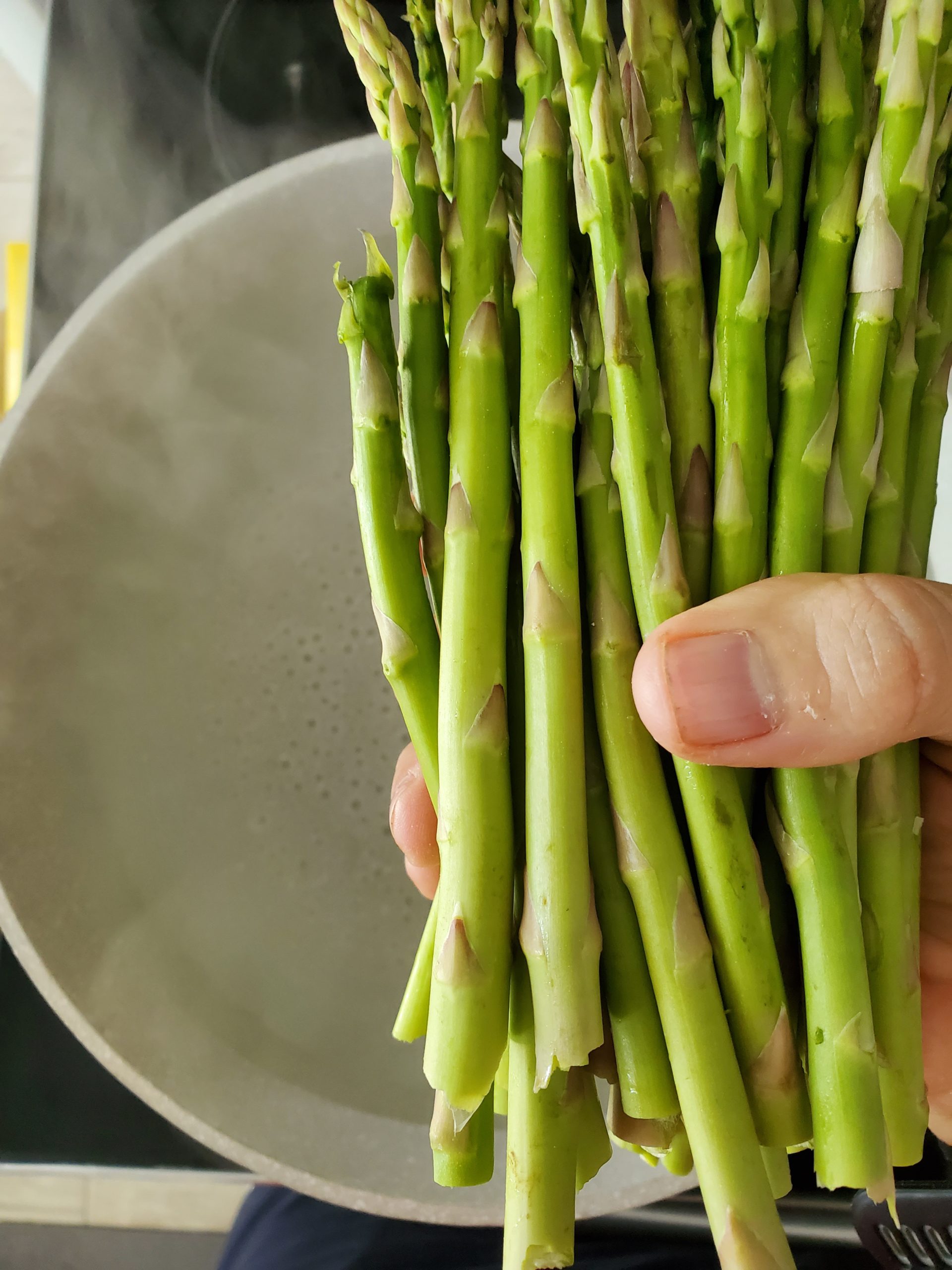 pot of boiling water with a bunch of asparagus about to cook