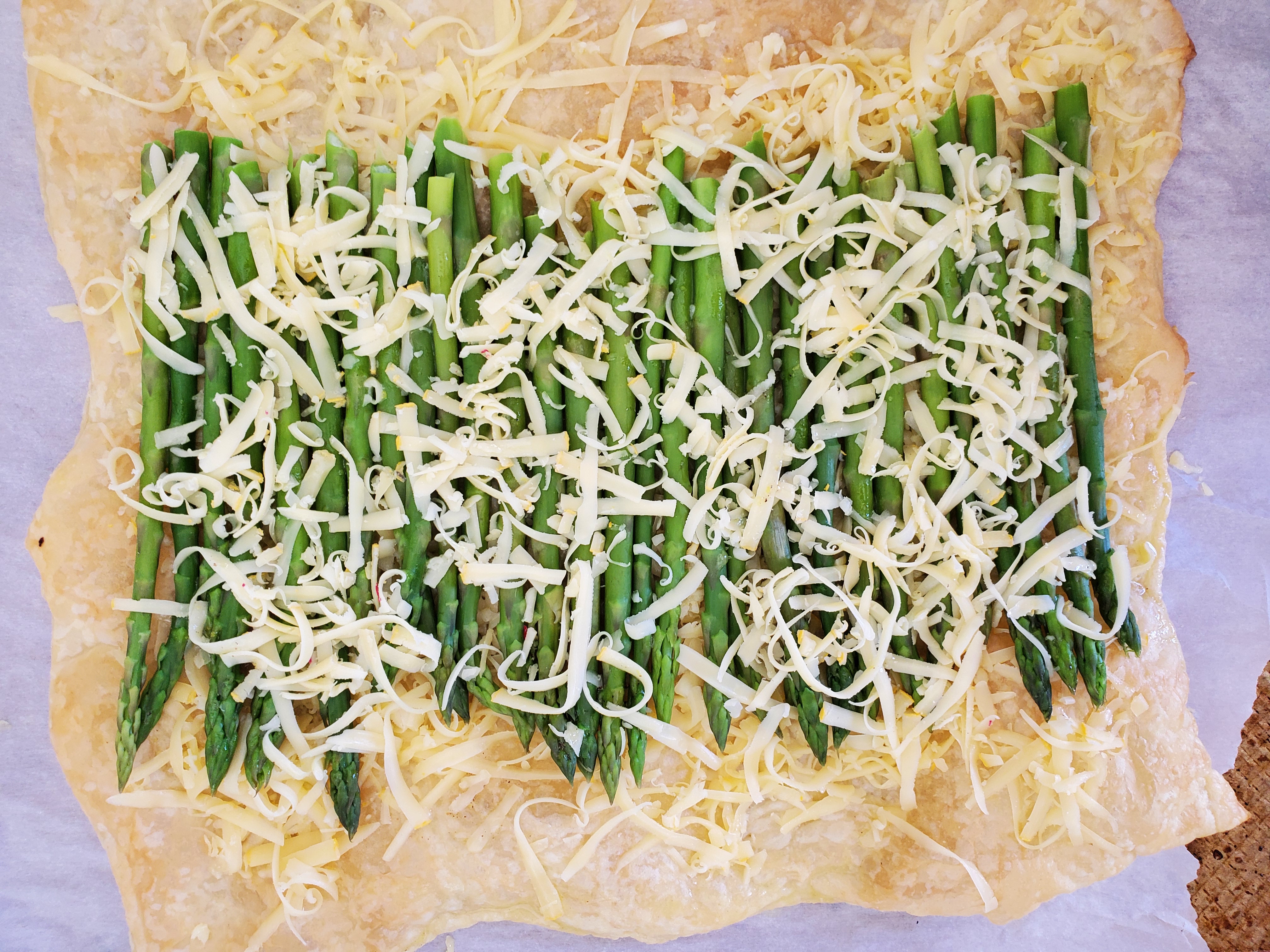extra cheese sprinkled on top of asparagus and puff pastry