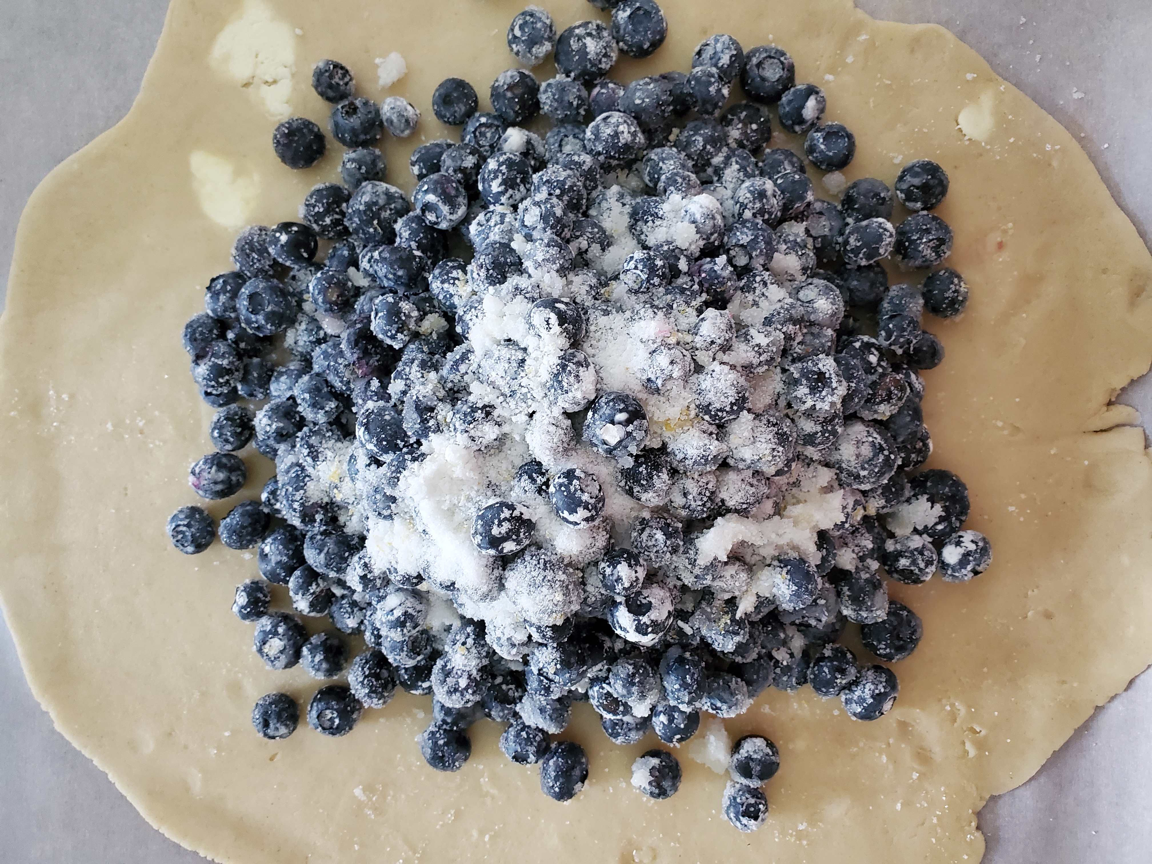 blueberries piled on pie dough