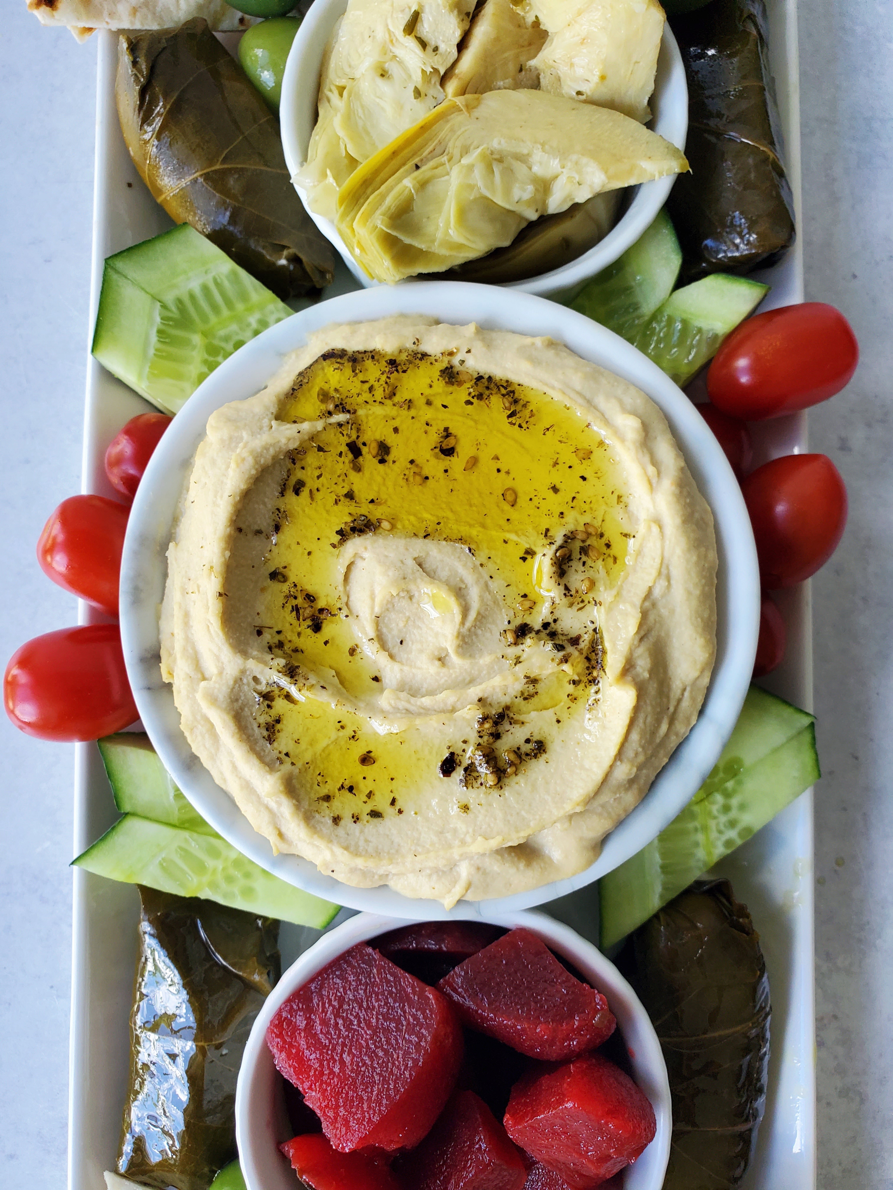 Close-up picture of homemade hummus with a drizzle of olive and sprinkle of za'atar