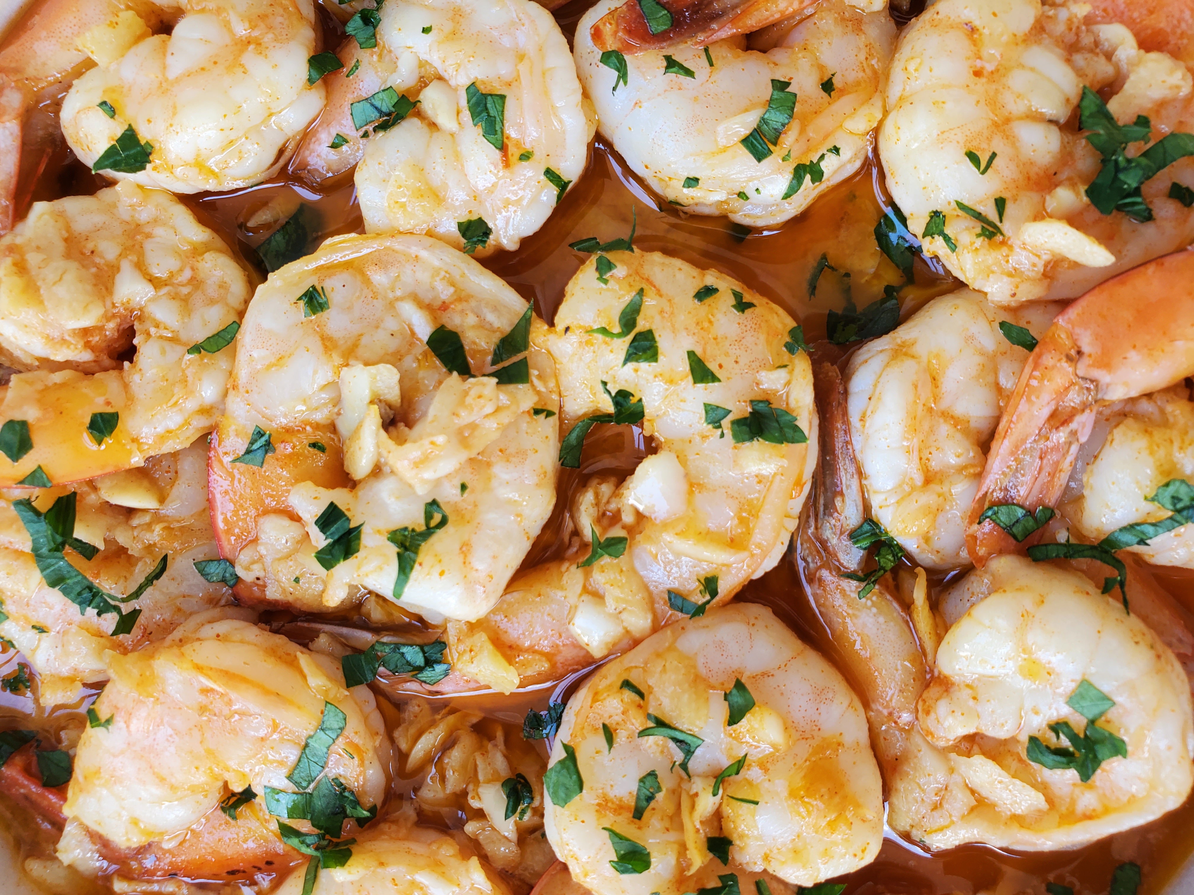 close up of shrimp in a garlic infused olive oil with paprika