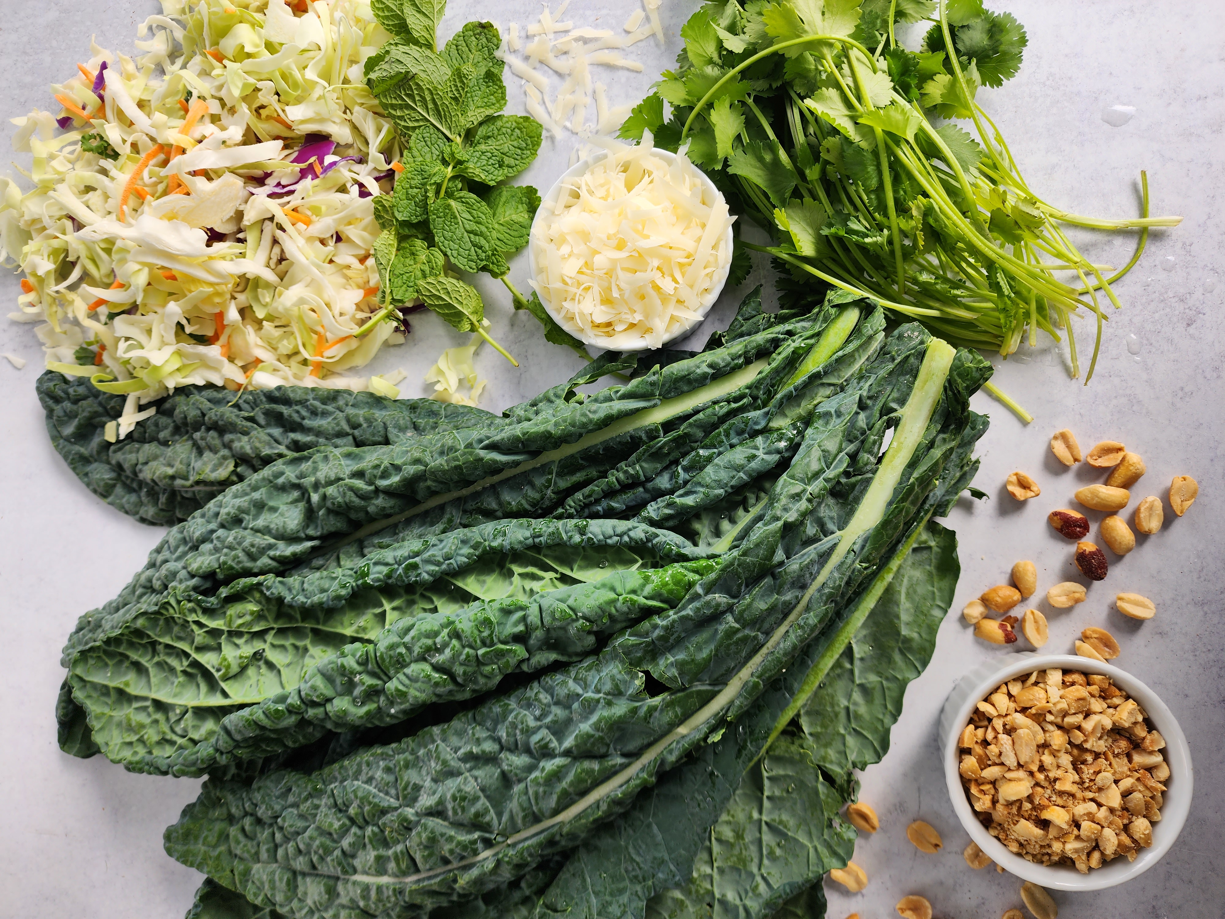 ingredients for a kale salad:  kale, cilantro, mint, cabbage, peanuts, parmesan cheese