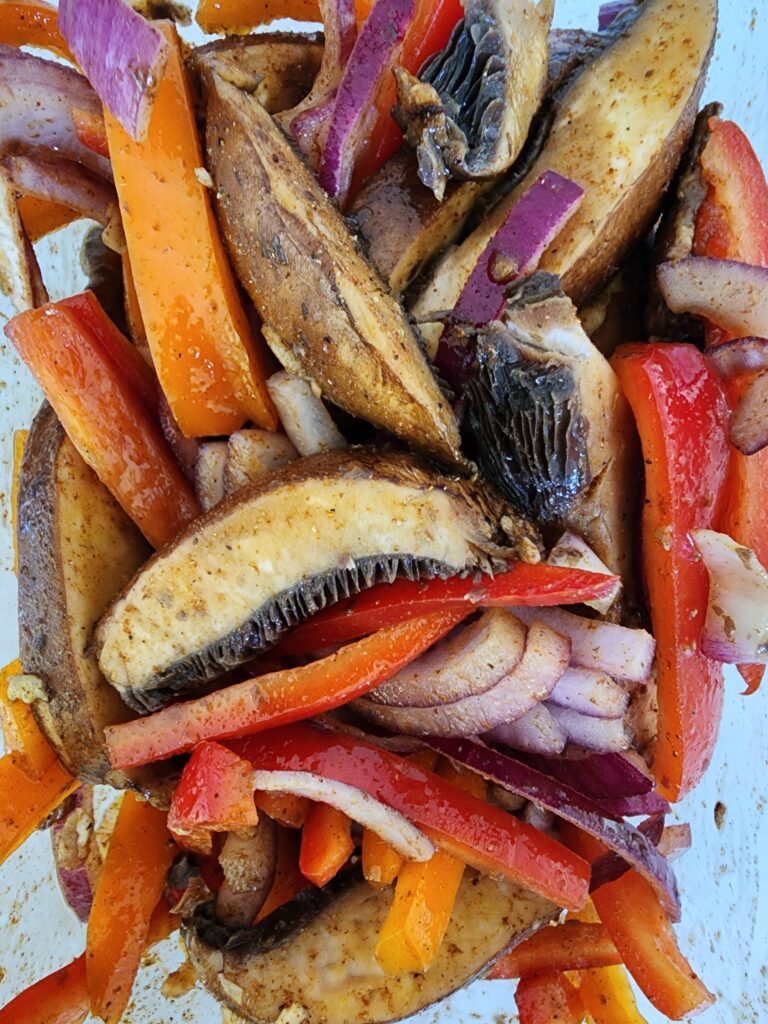 Portobello Mushrooms, Red and Orange Bell Peppers, Red Onion in a marinade for Portobello Fajitas
