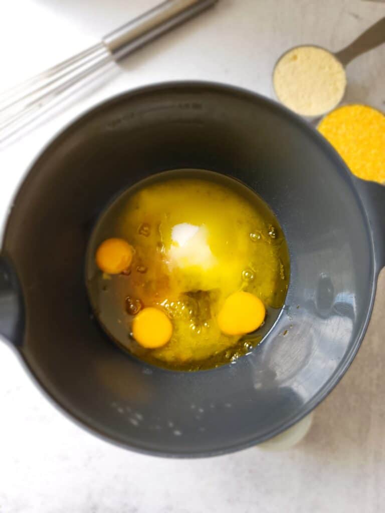bowl full of olive oil, sugar, and eggs to make an olive oil cake