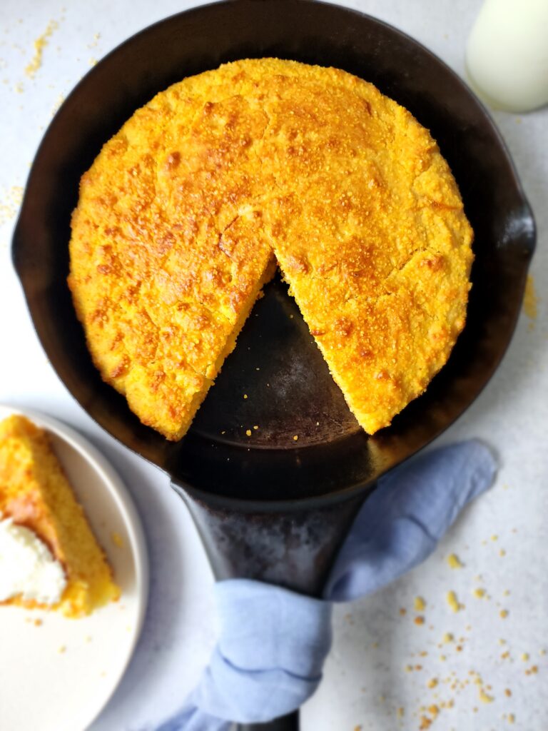 Skillet Cornbread with a slice cut and on a plate ready to eat