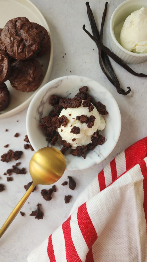 Bowl of vanilla ice cream with a brownie crumbled on top