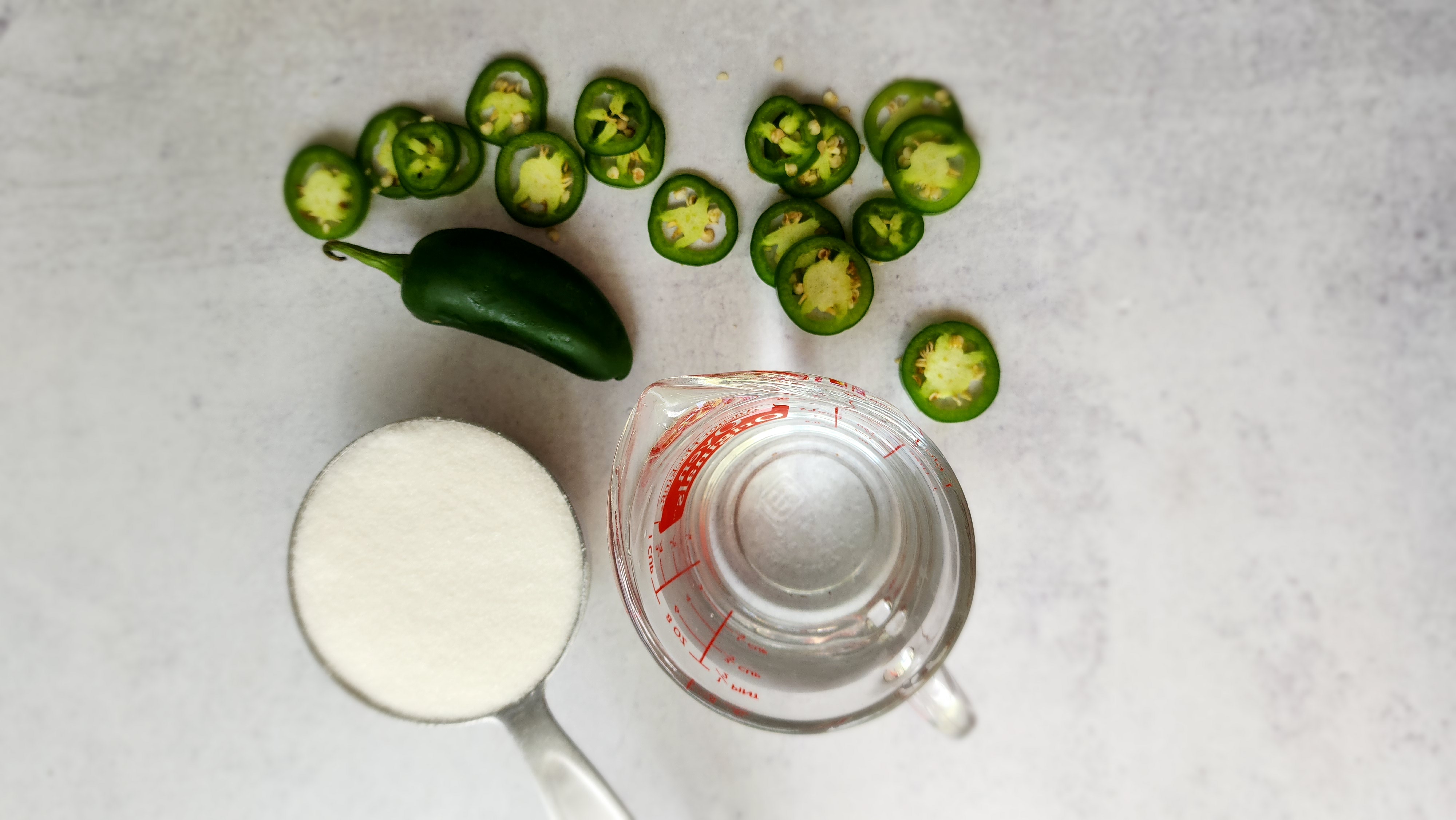 ingredients for a jalapeño simple syrup - water, sugar, jalapeños