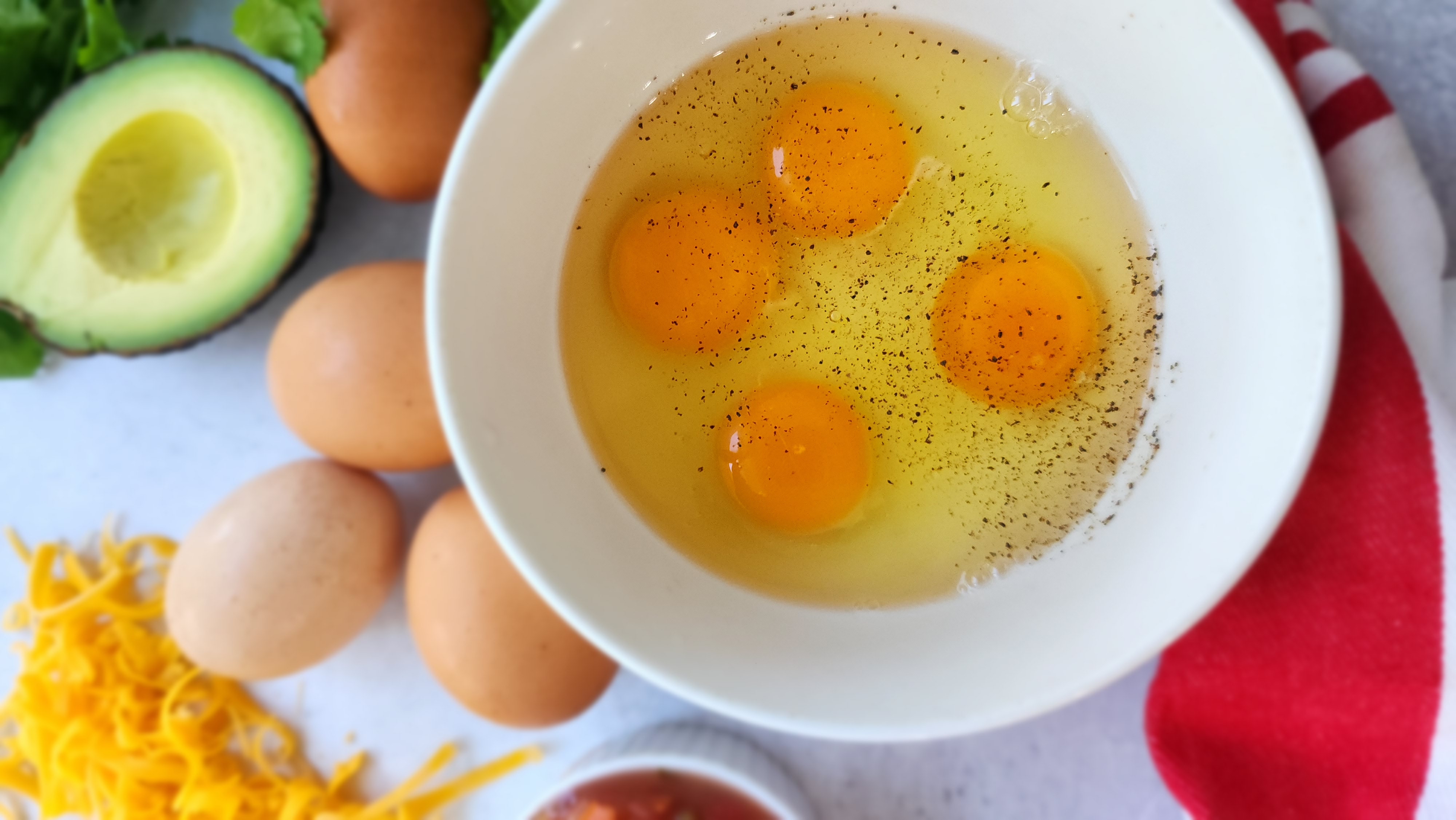 Cracked eggs in a bowl for breakfast tacos