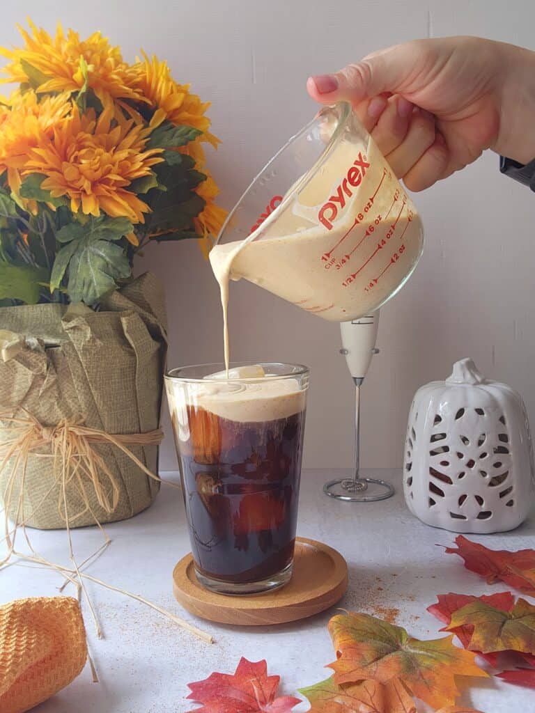 pouring the cream into the cold brew