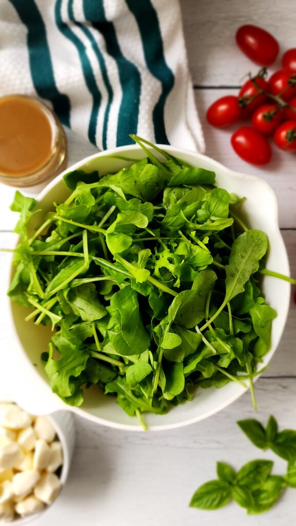 ingredients for a caprese Christmas wreath - arugula, mozzarella, basil, tomatoes