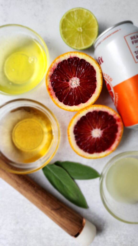 ingredients for a blood orange mocktail - blood orange, sage, sparkling water, simple syrup, egg white, lime juice