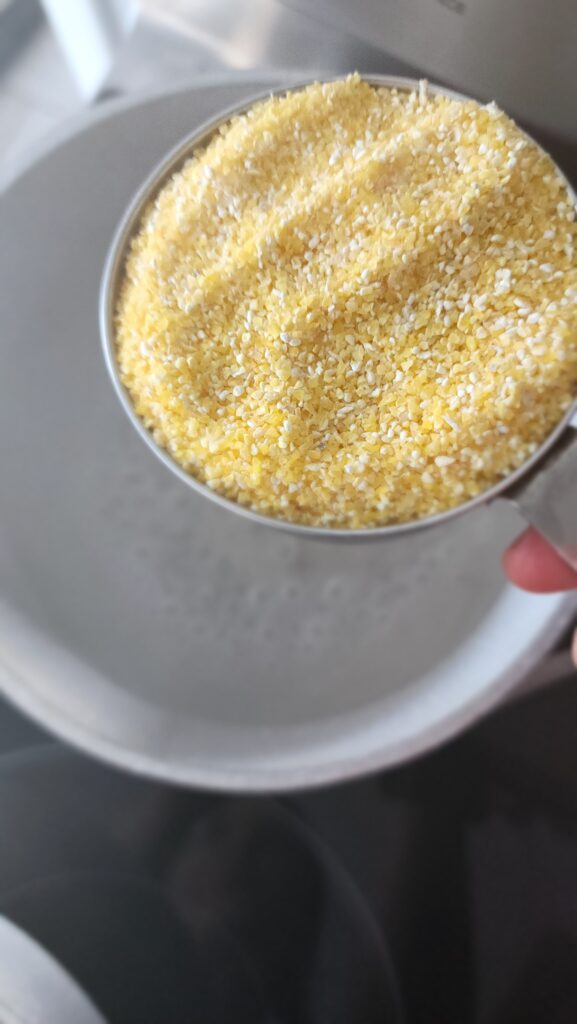 Perfect Polenta - adding the cornmeal into the pot of boiling water