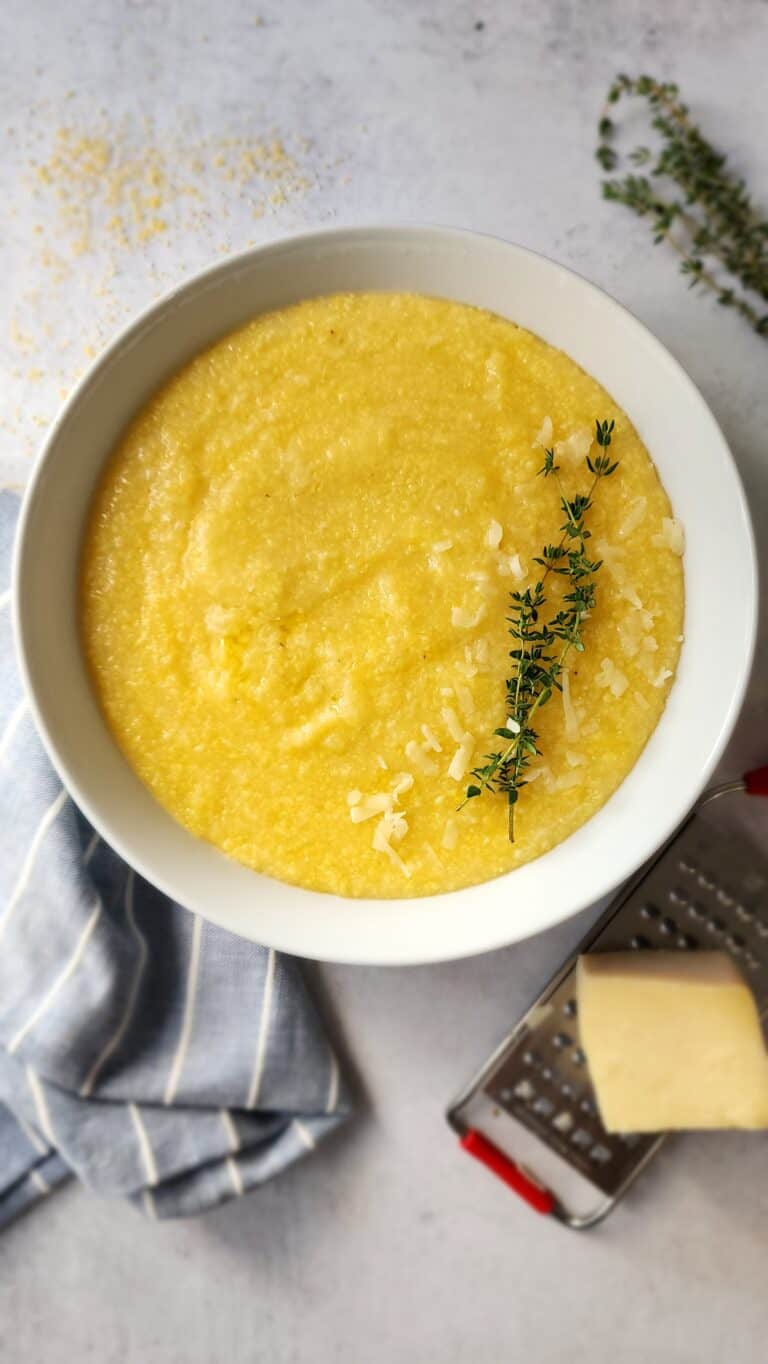 Perfect Polenta - plated in a bowl with a sprig of thyme on top