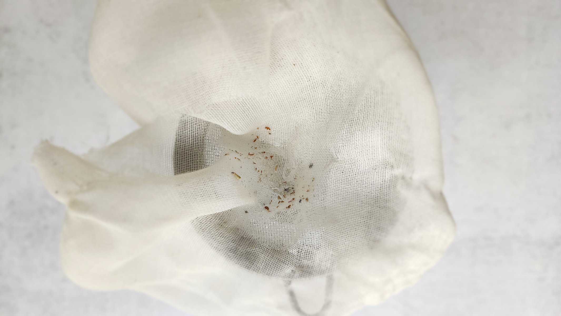 Top shot of the cheesecloth showing the debris removed from the lavender simple syrup