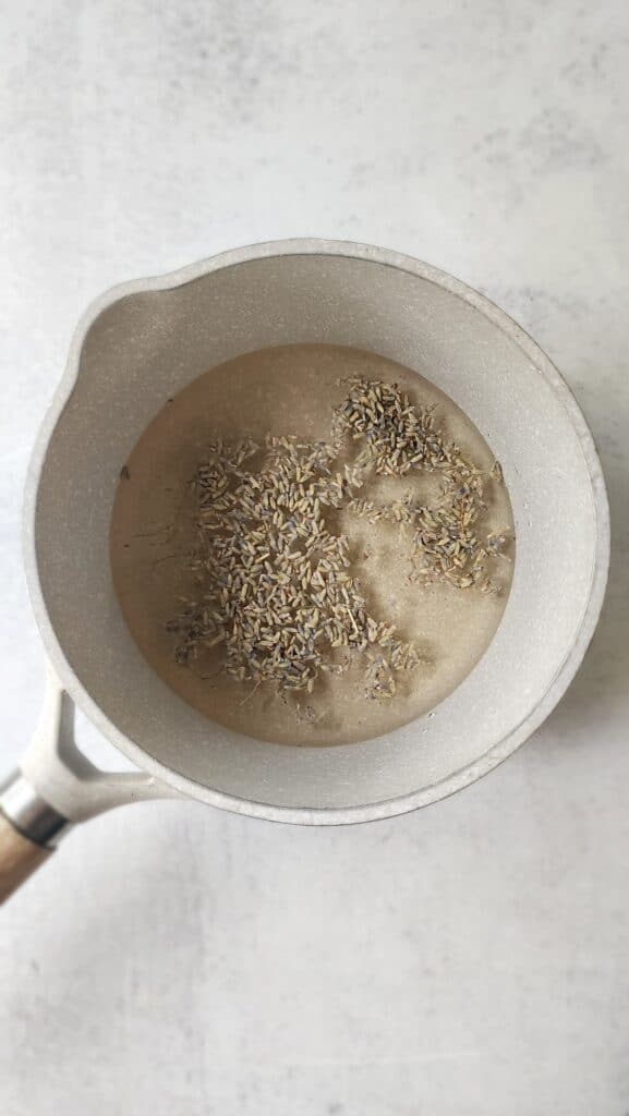 Steeping lavender in the mix of water and sugar after being boiled in a pan