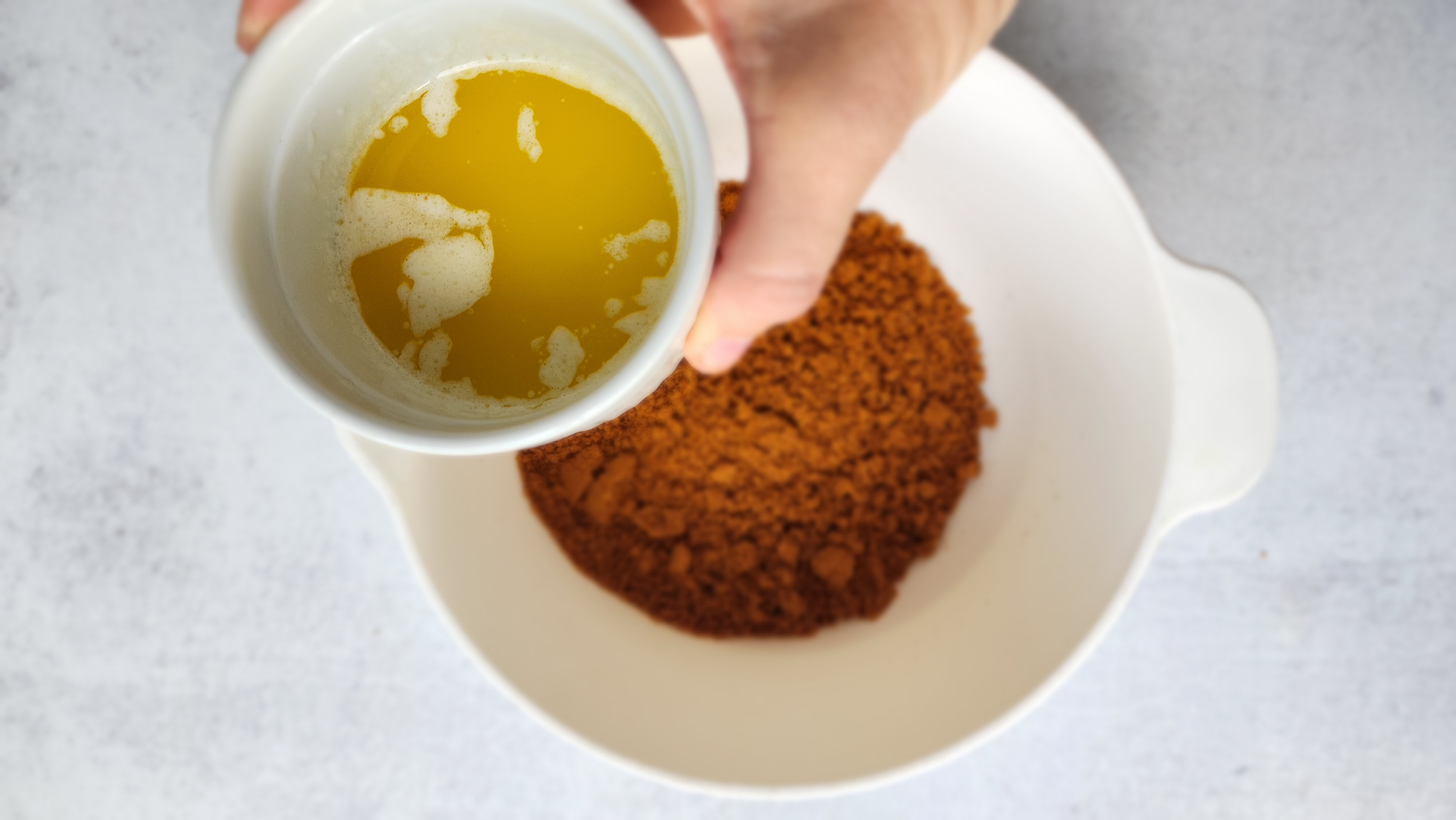 bowl of cookie crumbs with butter about to be added