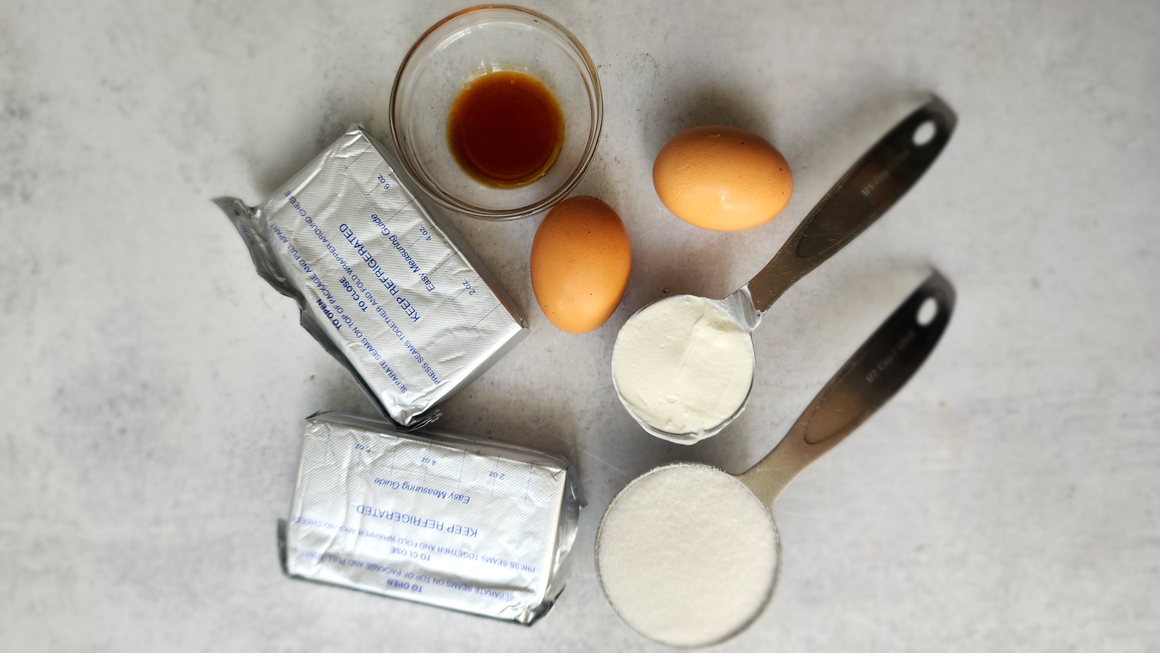 ingredients for mini cheesecake - cream cheese, sugar, eggs, vanilla, sour cream
