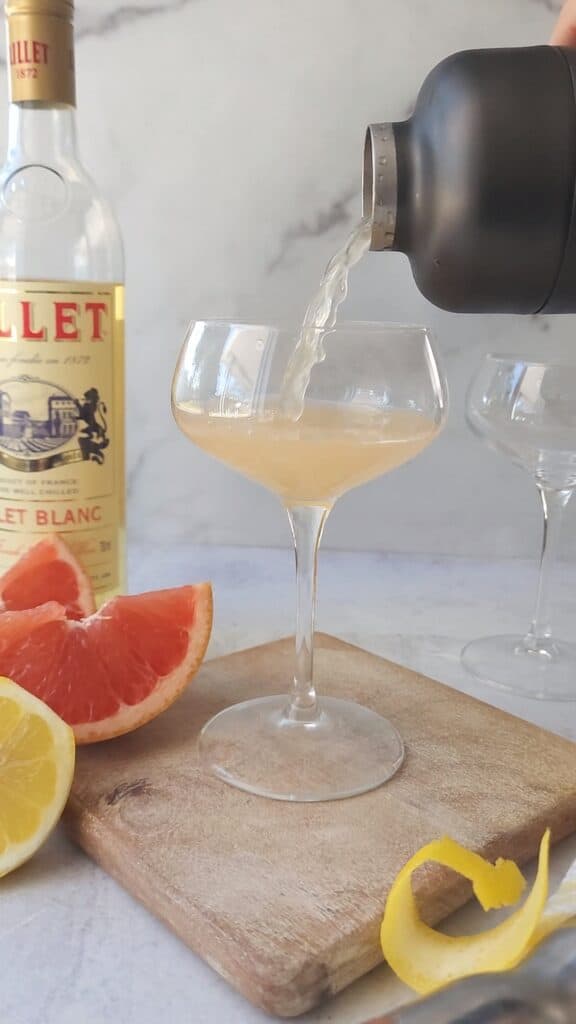 French Blonde Cocktail being poured into a coupe glass