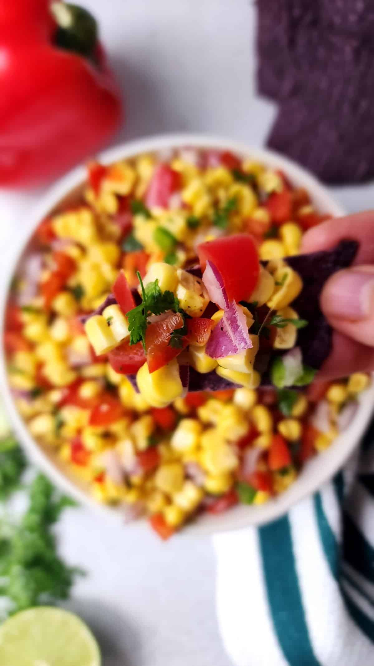 easy corn salsa being dipped with a chip