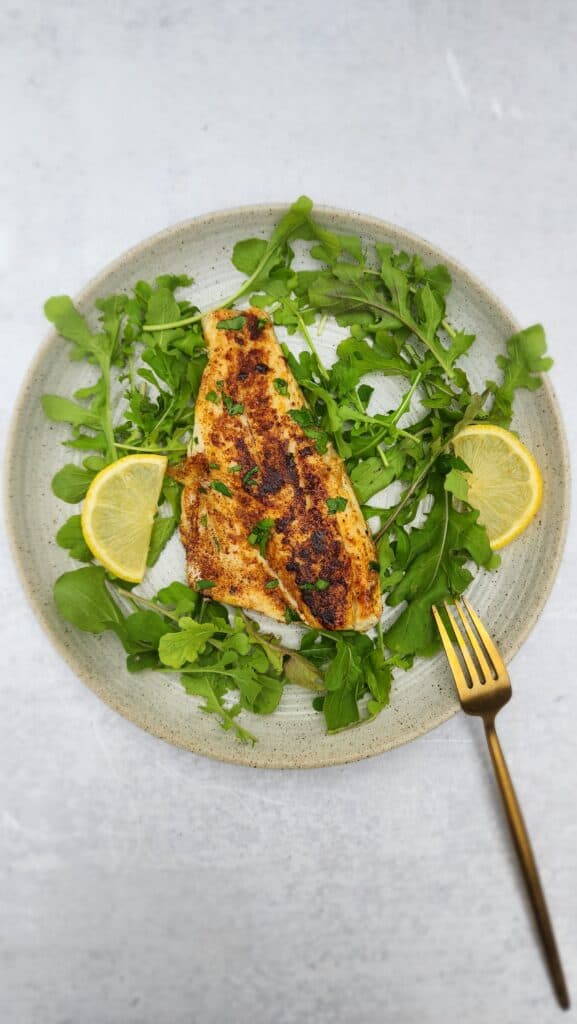 plate of pan-seared branzino over arugula