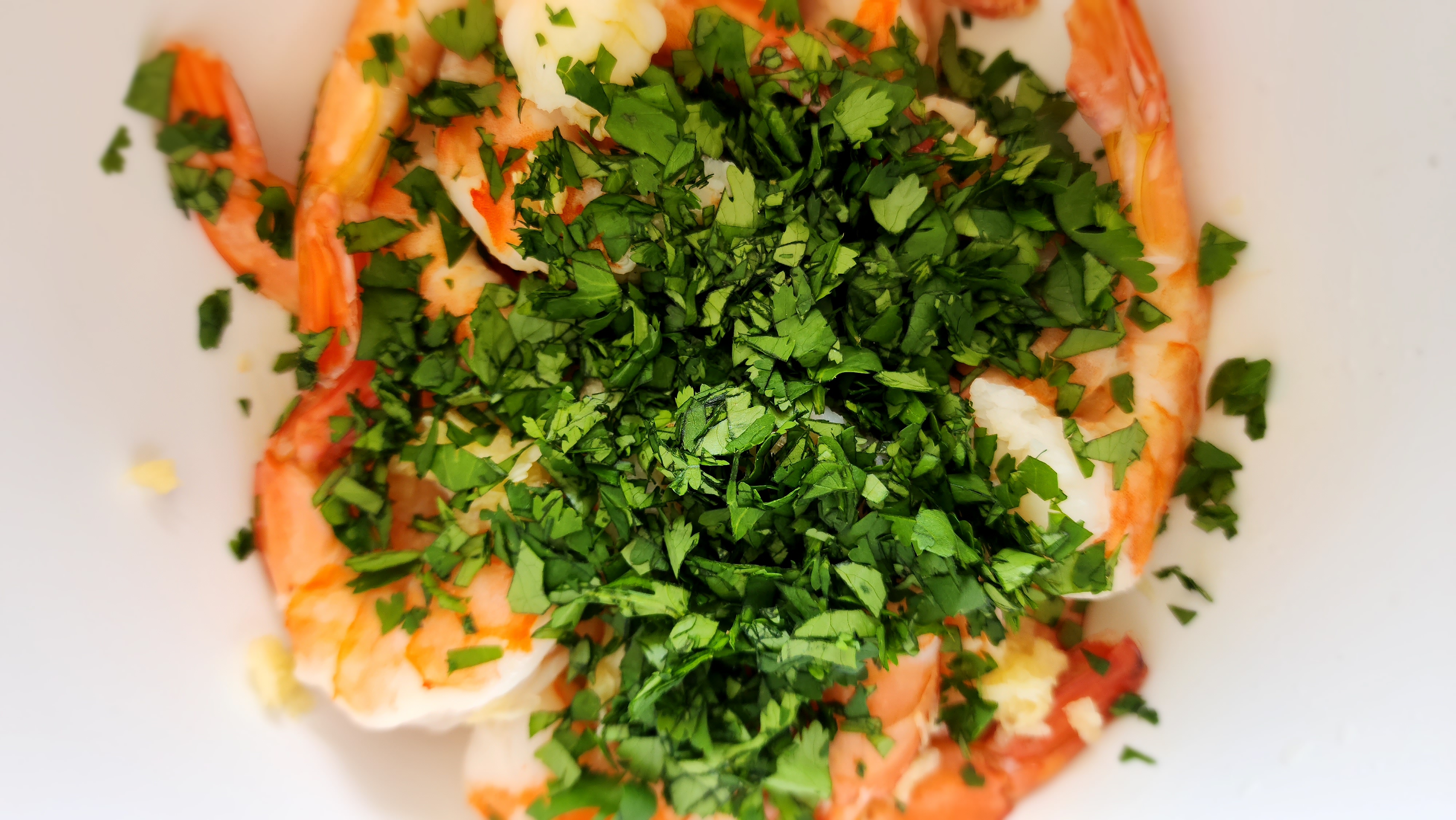 shrimp, garlic, olive oil, key lime juice, and cilantro in a bowl ready to be mixed for key lime shrimp
