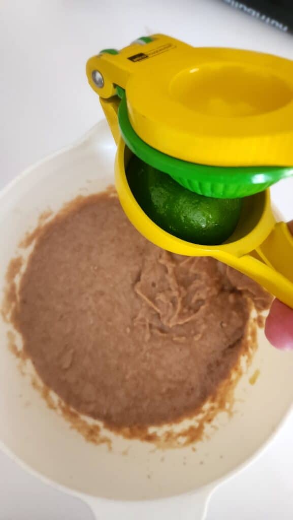 adding lime juice to homemade refried beans