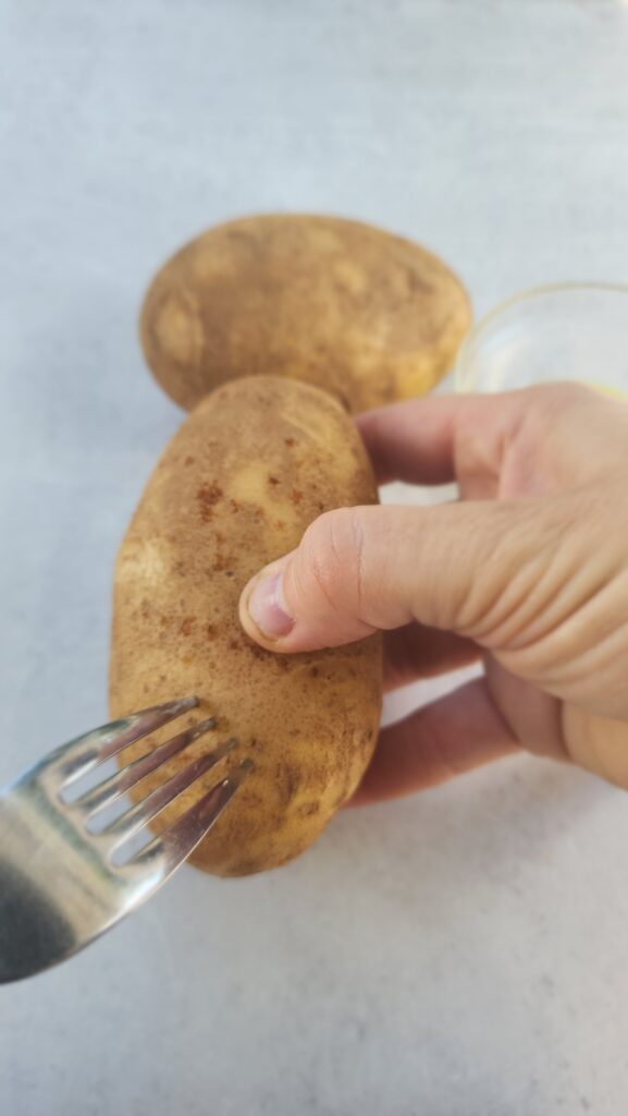 baked potato being pierced with a fork