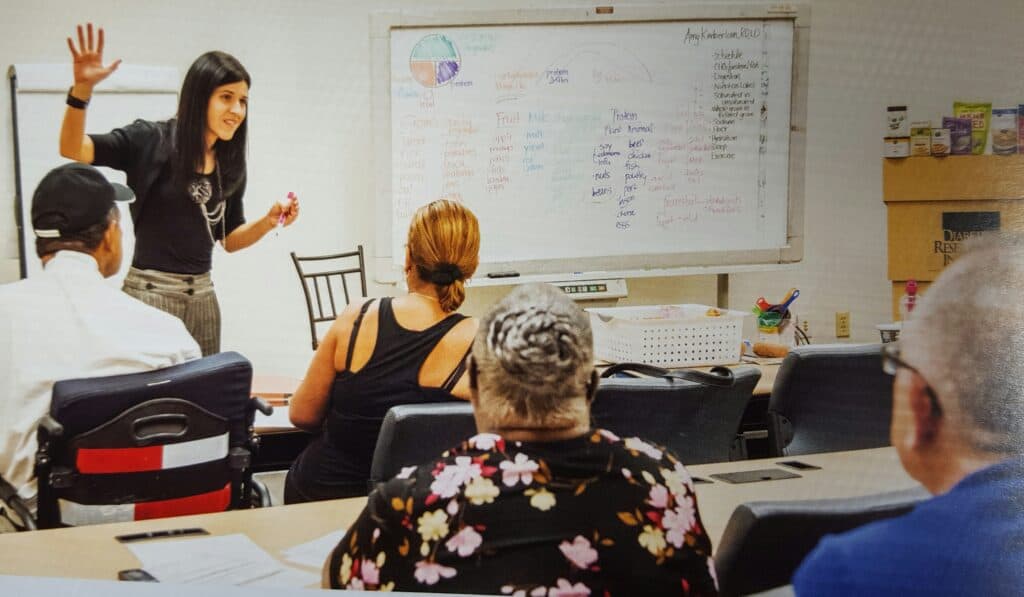 picture of me teaching a diabetes management class with participants in the audience
