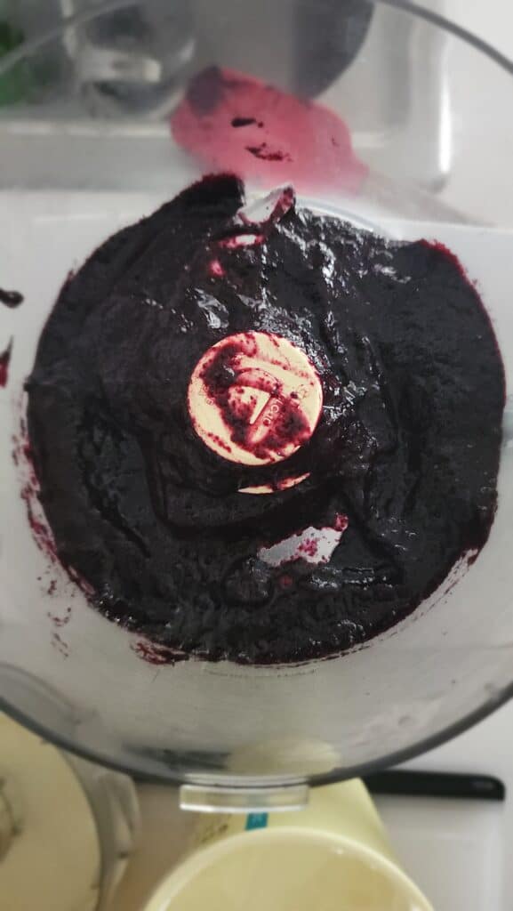 blueberries in a food processor pureed to make frozen blueberry yogurt