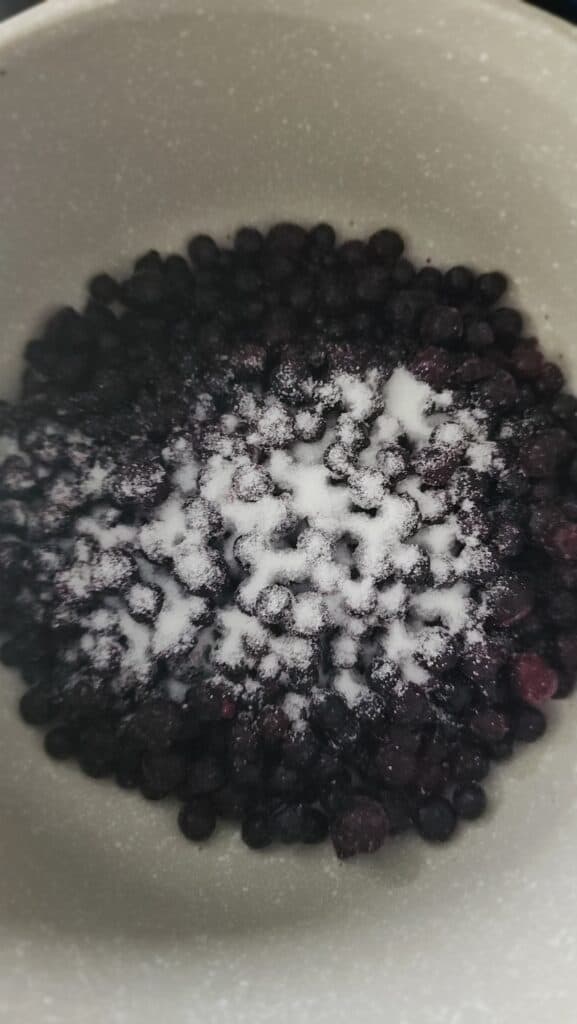 sugar added to the frozen blueberries about to be simmered for frozen blueberry yogurt