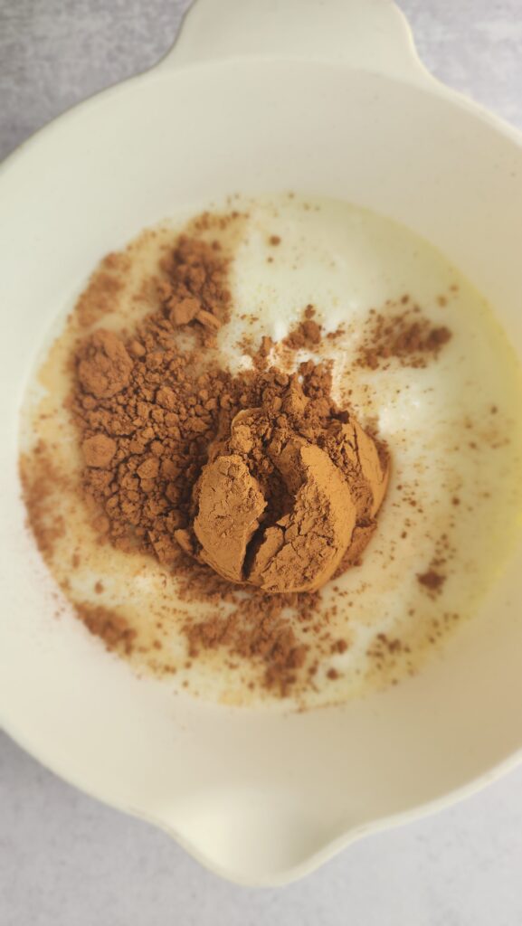 adding cocoa powder to the milk and Greek yogurt to make chocolate chia seed pudding