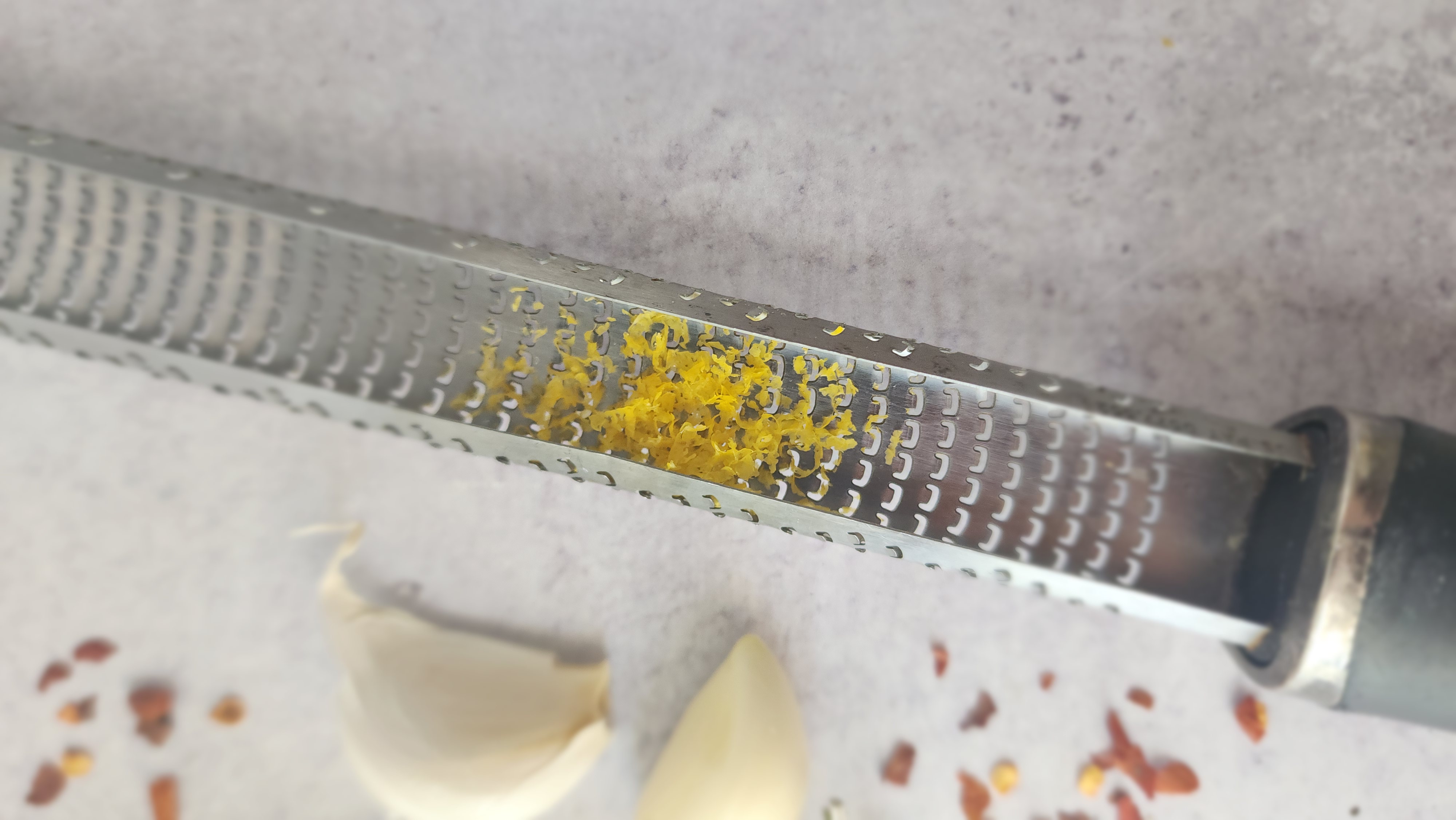 grater with lemon zest as an ingredient for bread dipping oil