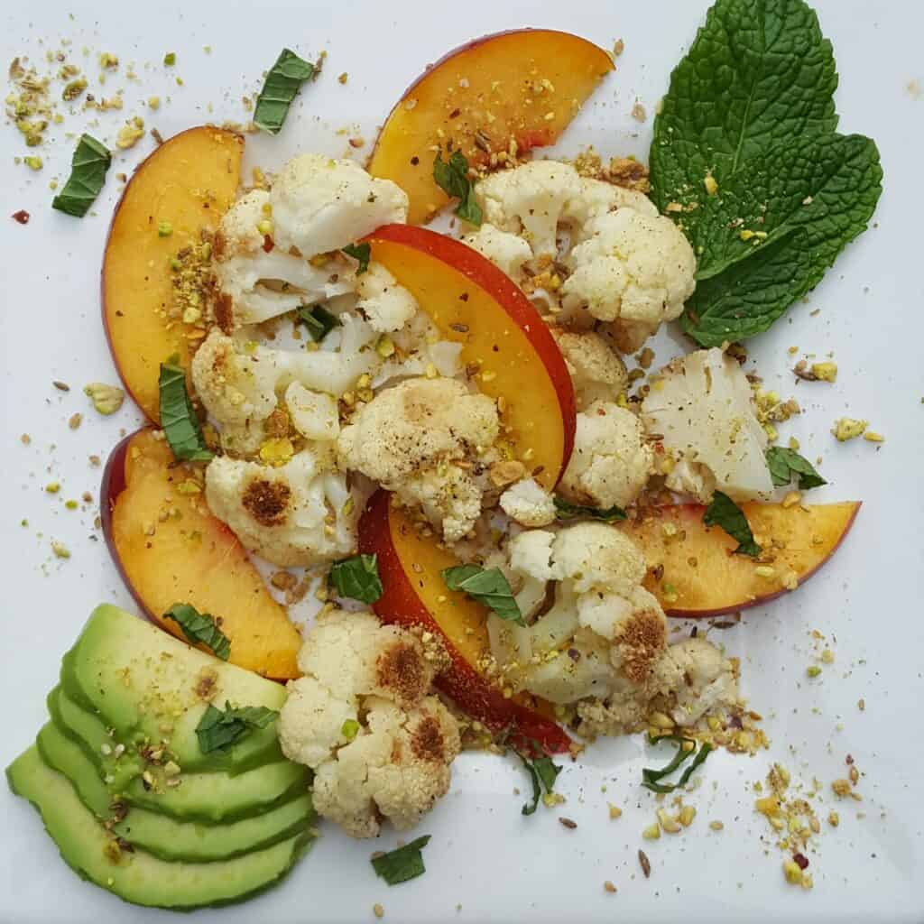 plate of nectarines with cauliflower, avocado, and dukka
