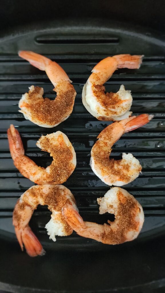 seasoned blackened shrimp in the grill pan cooking
