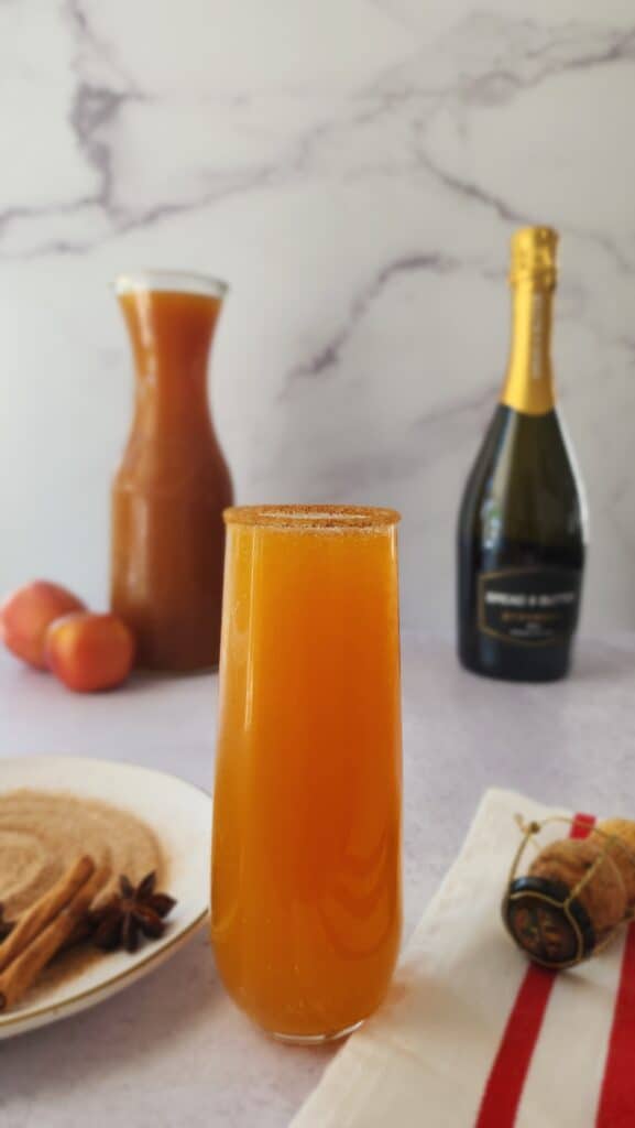 An Apple cider mimosa with cinnamon sugar rim